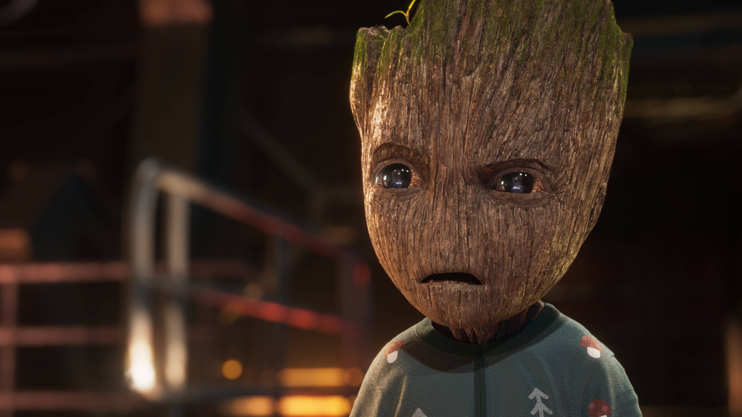 Baby Groot 桌布 壁紙 — 銀河守護者中格魯特的近鏡，身穿節日毛衣，在溫暖的環境燈光下露出擔憂的表情。