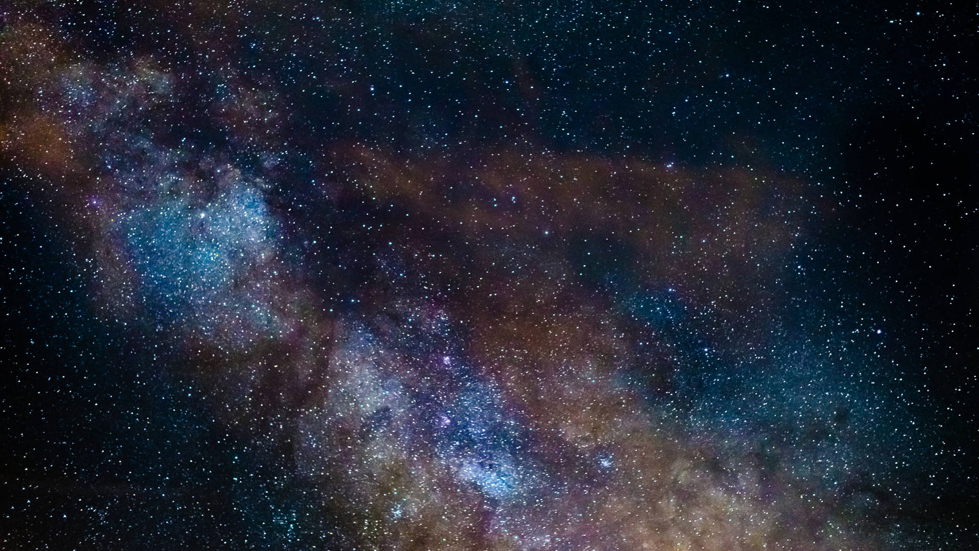 太空 桌布 壁紙 — 銀河系令人驚嘆的景觀，旋轉的宇宙塵埃和無數星星在深藍色、紫色和橙色中閃耀。