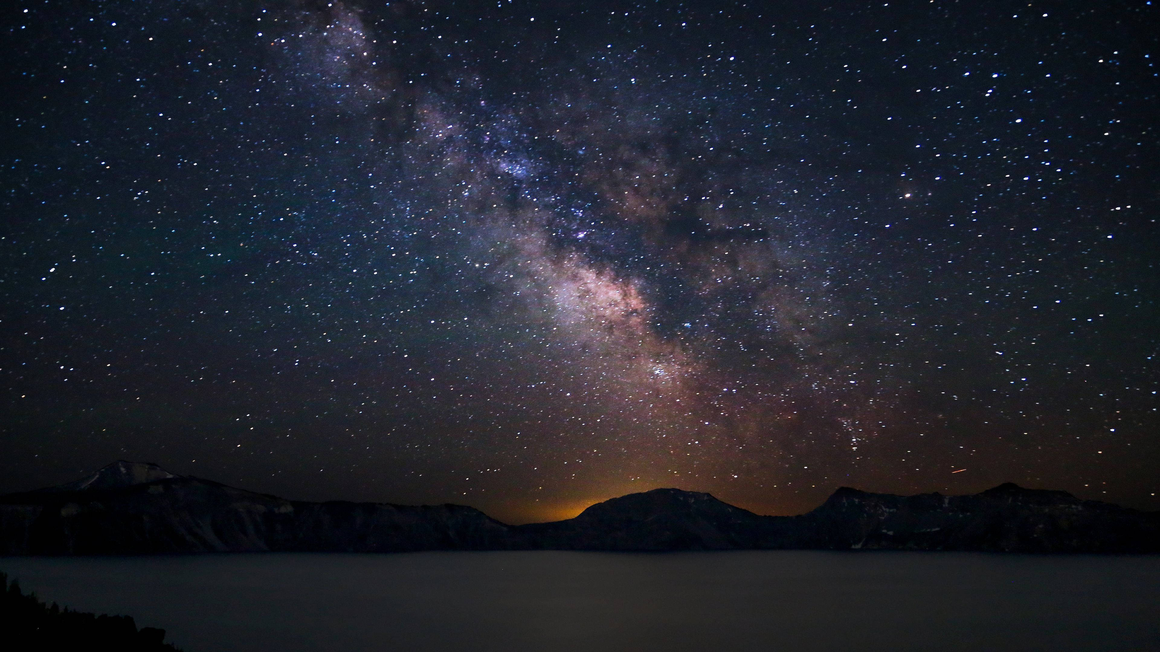 4K ultra HD galaxy 桌布 壁紙 — 銀河系在寧靜的湖泊和黑暗的山脈上空燦爛地彎曲，在繁星點點的夜空下。