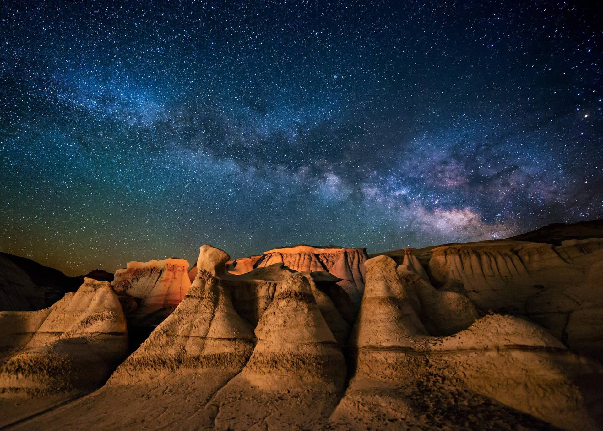 星空之夜，銀河系照亮沙漠岩層。