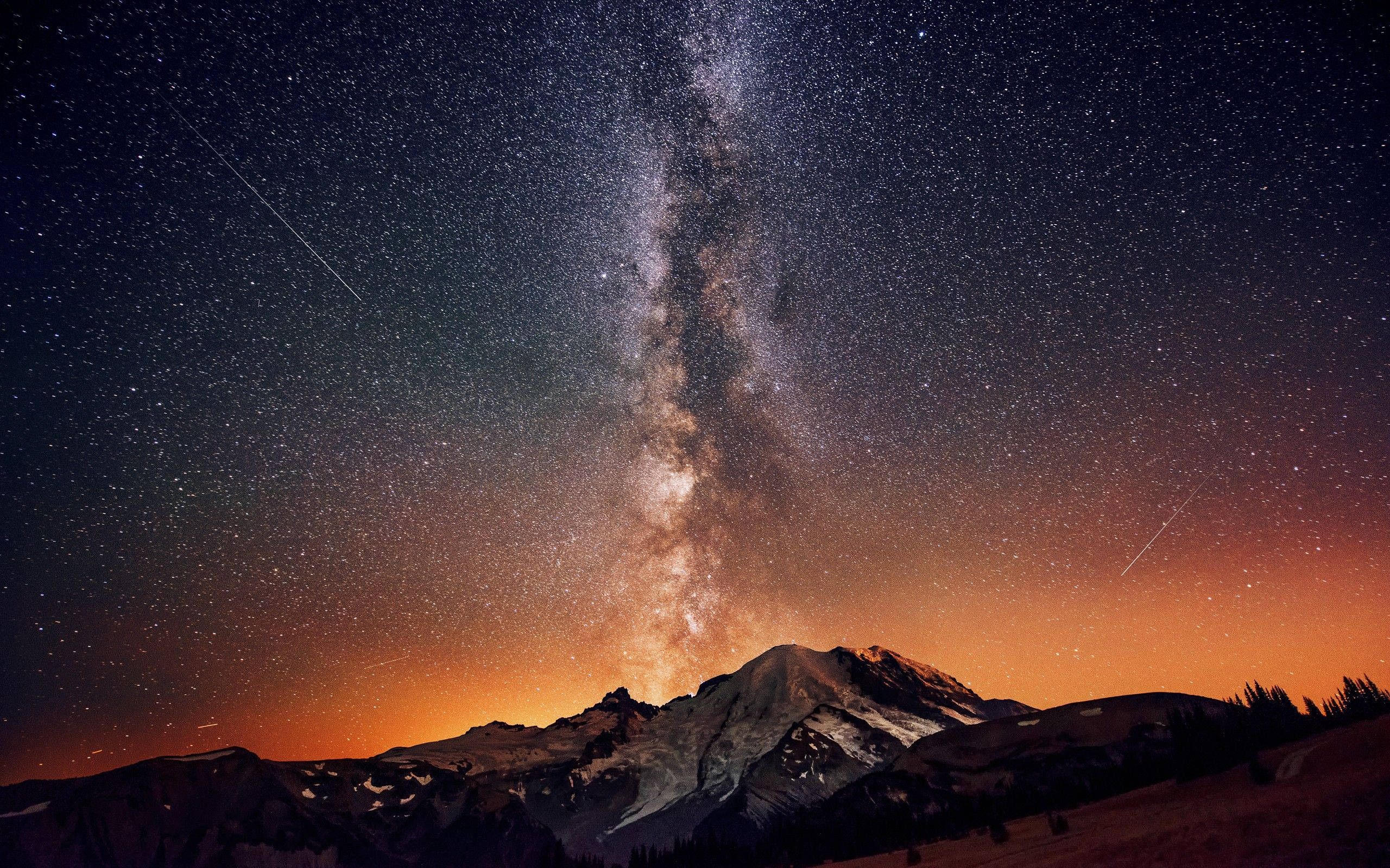 夜空 桌布 壁紙 — 銀河系在星空下戲劇性地拱起在積雪的山峰之上。
