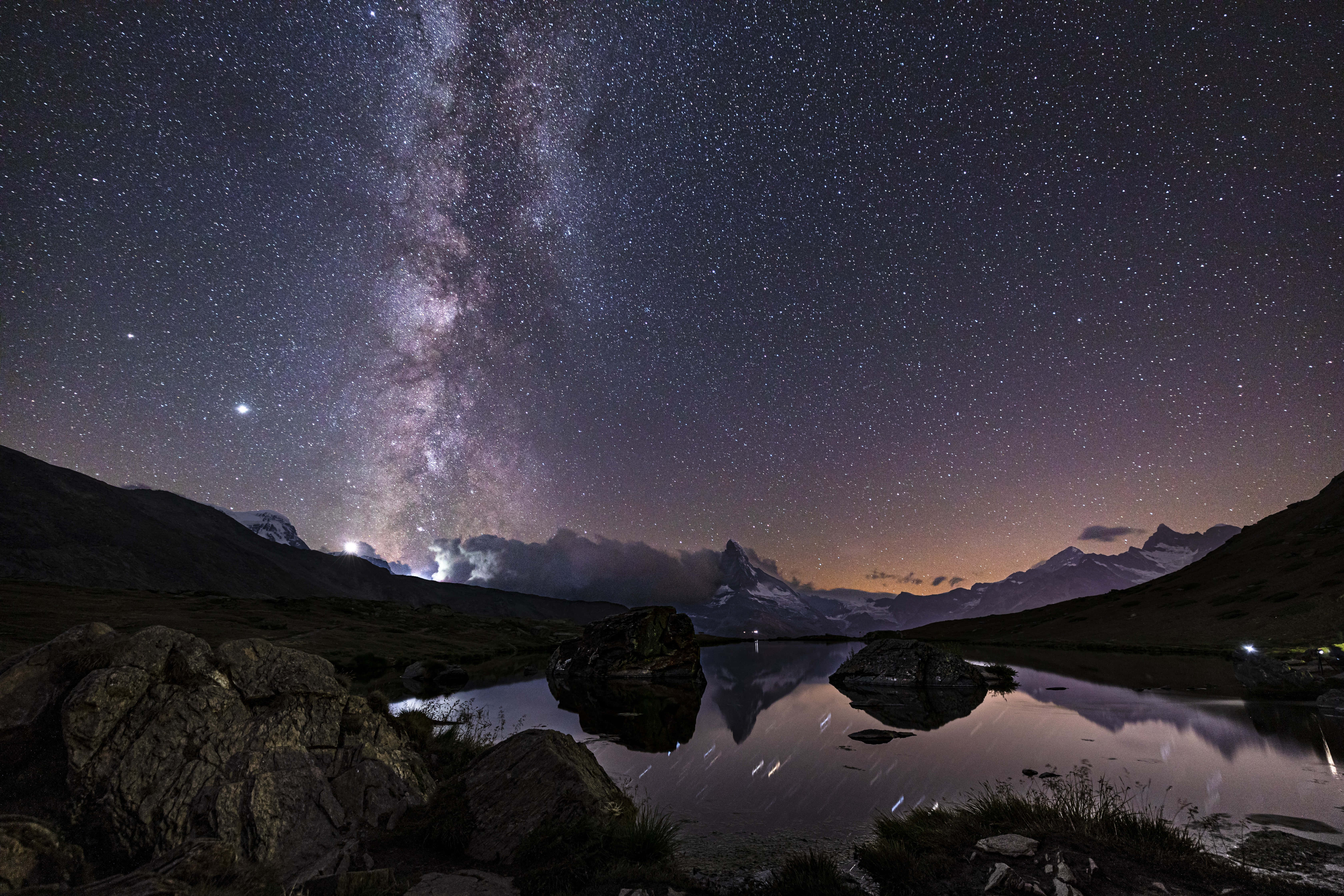 Beautiful Space 桌布 壁紙 — 銀河系在積雪的山峰上空彎曲，倒映在寧靜的高山湖泊中，星空璀璨。