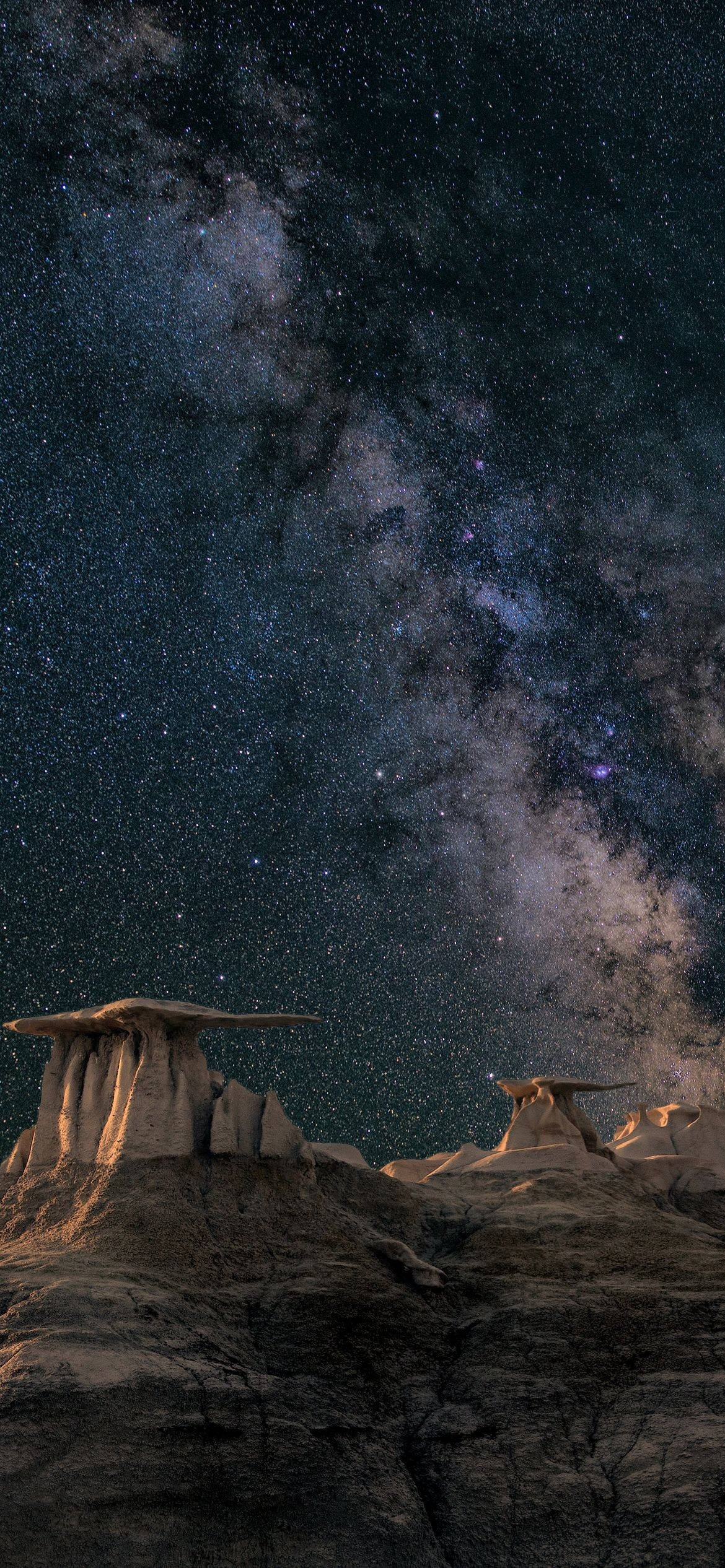 桌布 壁紙 — 銀河系在繁星點點的夜空下，在崎嶇的沙漠岩層上燦爛地彎曲。