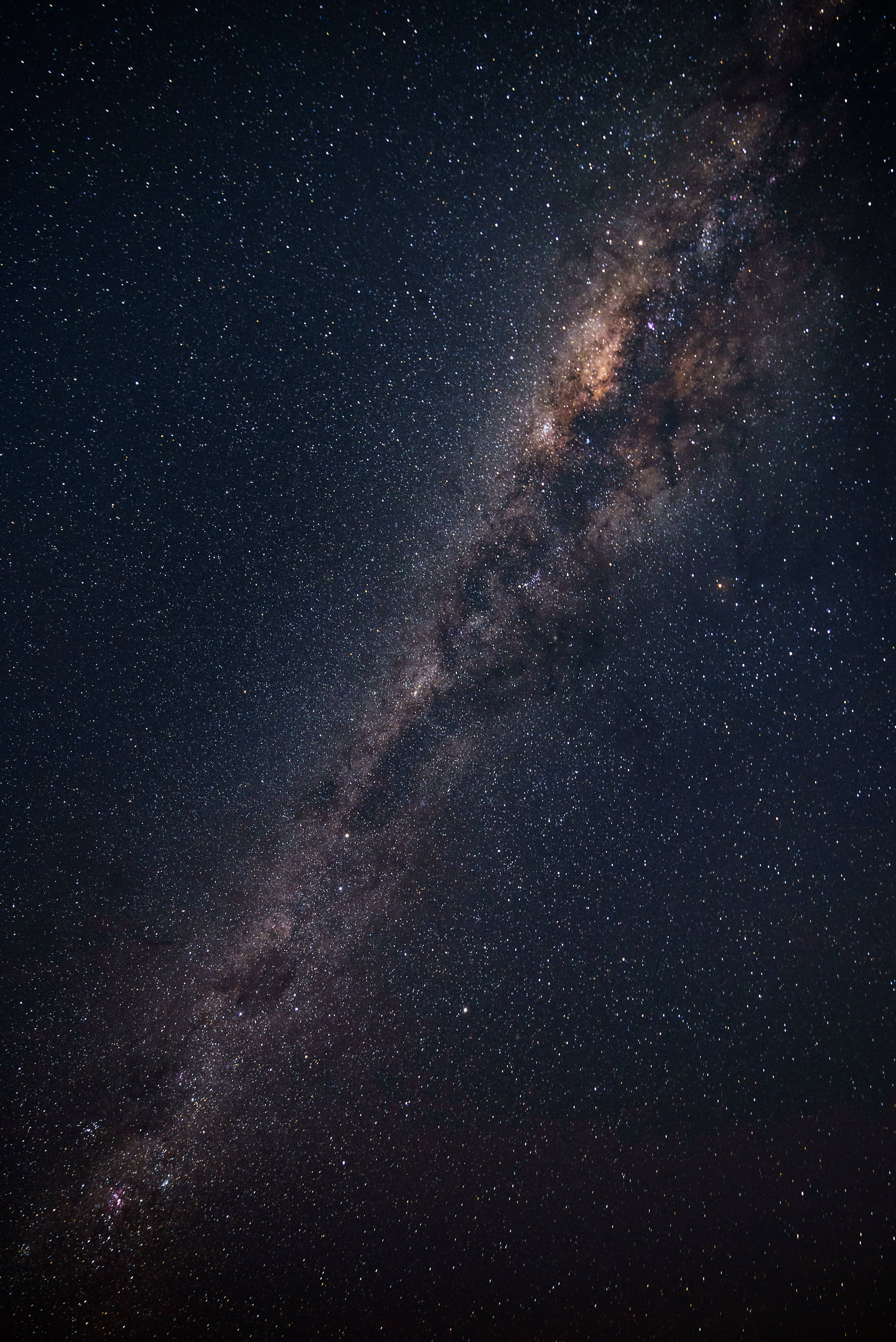 Coolest iPhone 桌布 壁紙 — 銀河系橫跨滿天繁星的夜空，散發光芒的星雲和黑暗的宇宙塵埃，令人嘆為觀止。