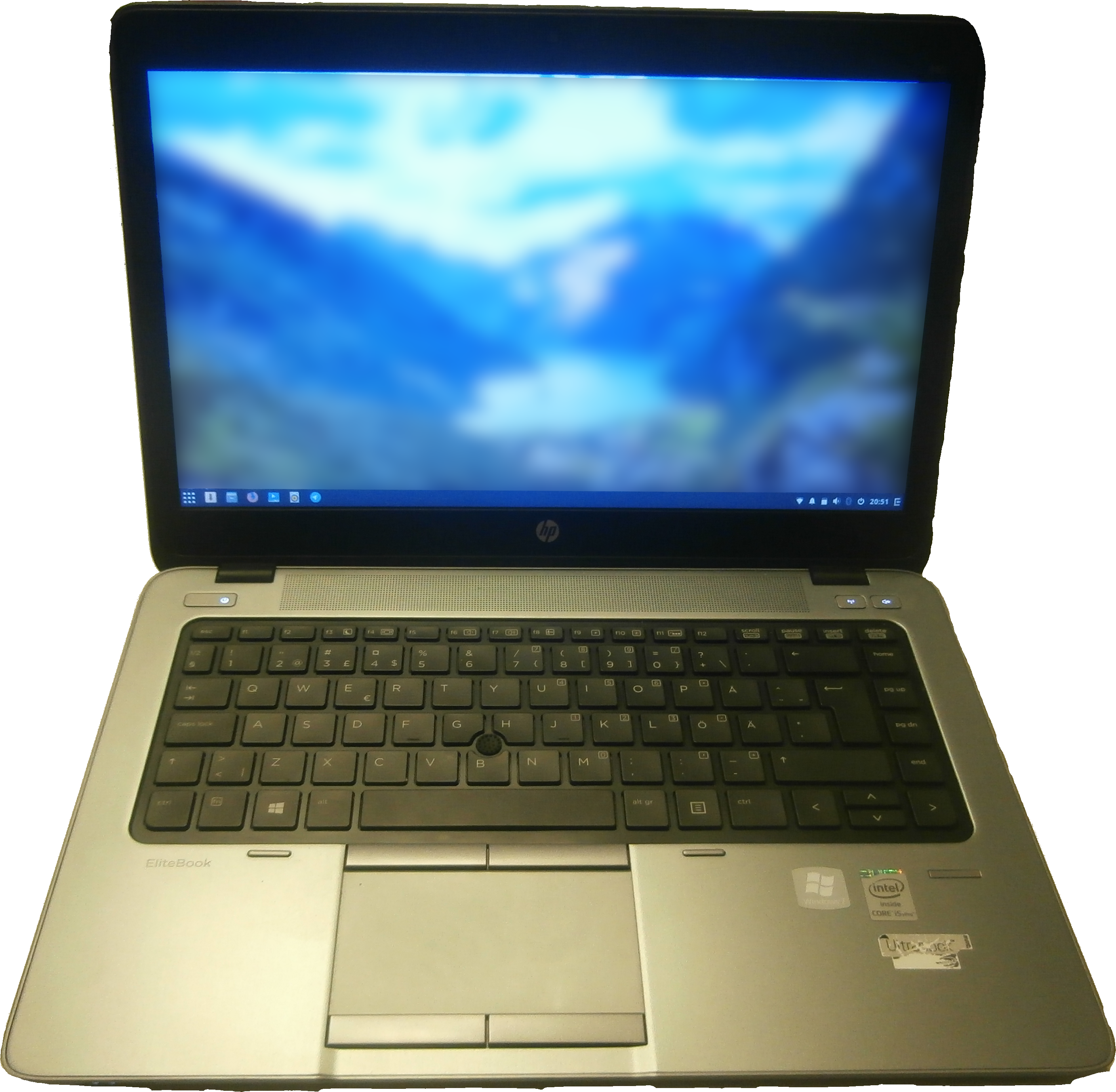 Hp Logo 桌布 壁紙 — 銀色 HP EliteBook 筆記型電腦在黑色背景前打開，顯示藍色山脈桌布。