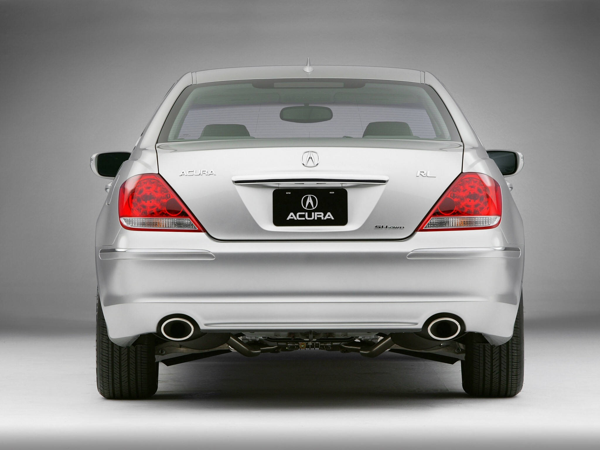 Acura 桌布 壁紙 — 銀色Acura RL豪華轎車的後視圖，帶有紅色尾燈和雙排氣管，背景為中性灰色工作室。