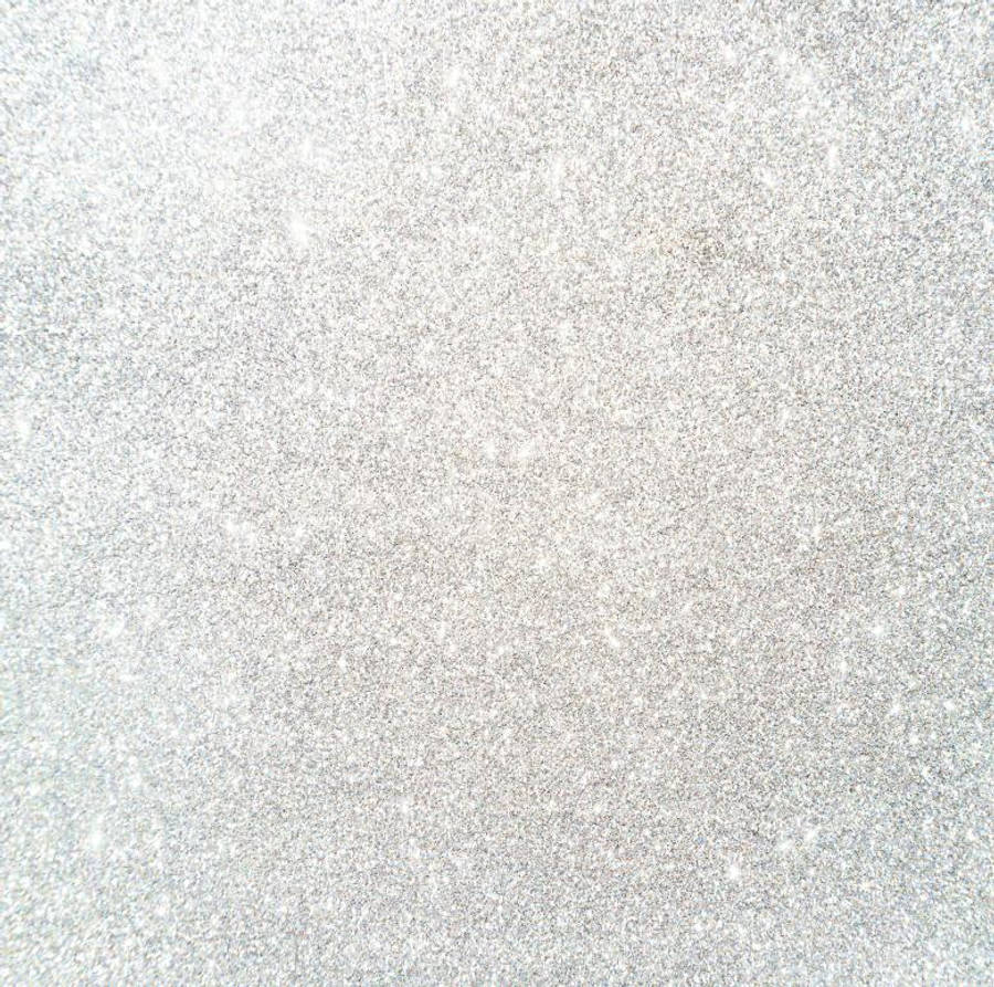 Silver Glitter 桌布 壁紙 — 銀色亮粉的微距特寫，細小顆粒在紋理表面上捕捉光線。