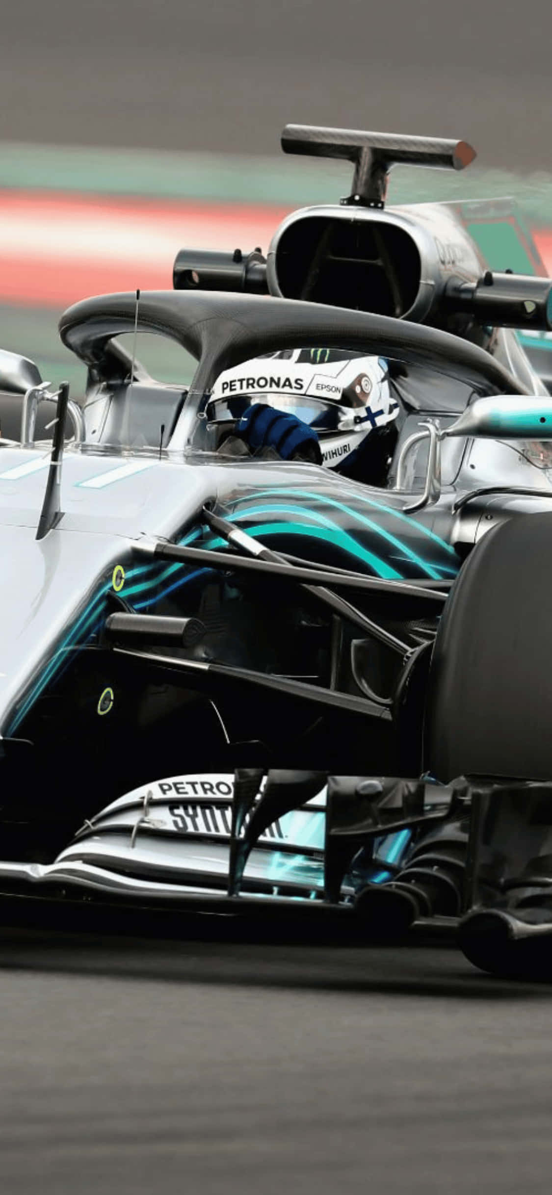 F1 2018 桌布 壁紙 — 銀色和藍綠色一級方程式賽車的特寫，車手戴著Petronas頭盔在賽道上飛馳。