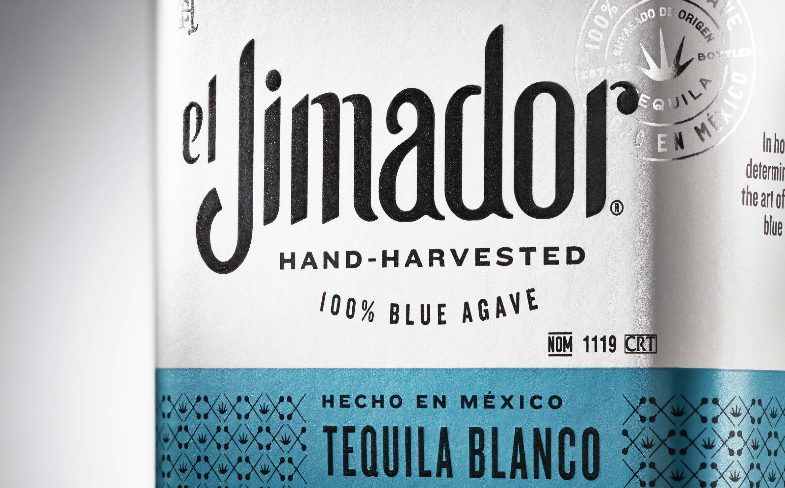 drinks 桌布 壁紙 — 銀色和藍綠色的 El Jimador 龍舌蘭酒瓶標籤特寫，凸顯手工採摘的藍色龍舌蘭和墨西哥產地。