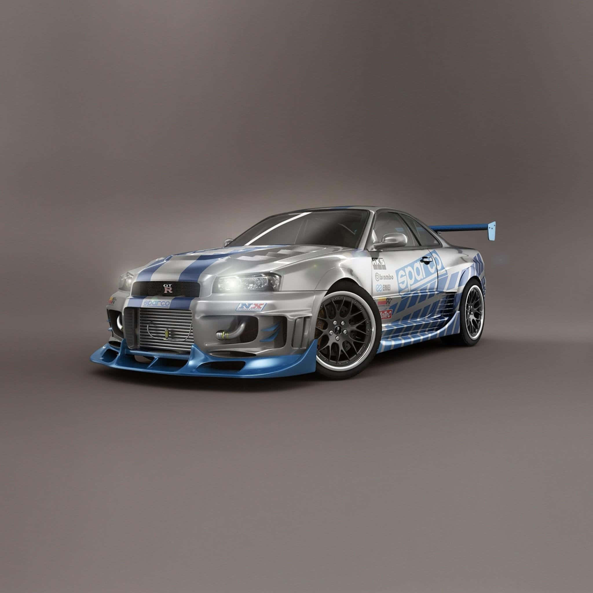 桌布 壁紙 — 銀色和藍色的日產Skyline GT-R賽車，帶有贊助商貼紙和空氣動力學車身套件，置於中性灰色工作室背景前。
