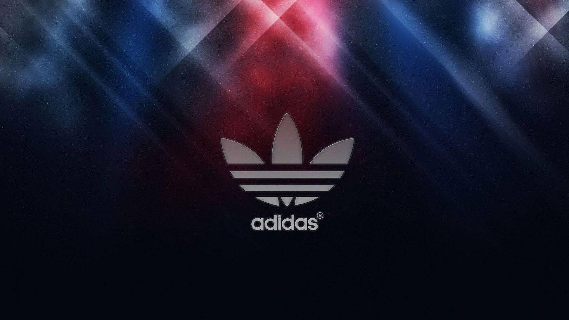 愛迪達 桌布 壁紙 — 銀色的 Adidas 三葉草標誌在帶有紅色和藍色斜向光線的深色背景上發光。