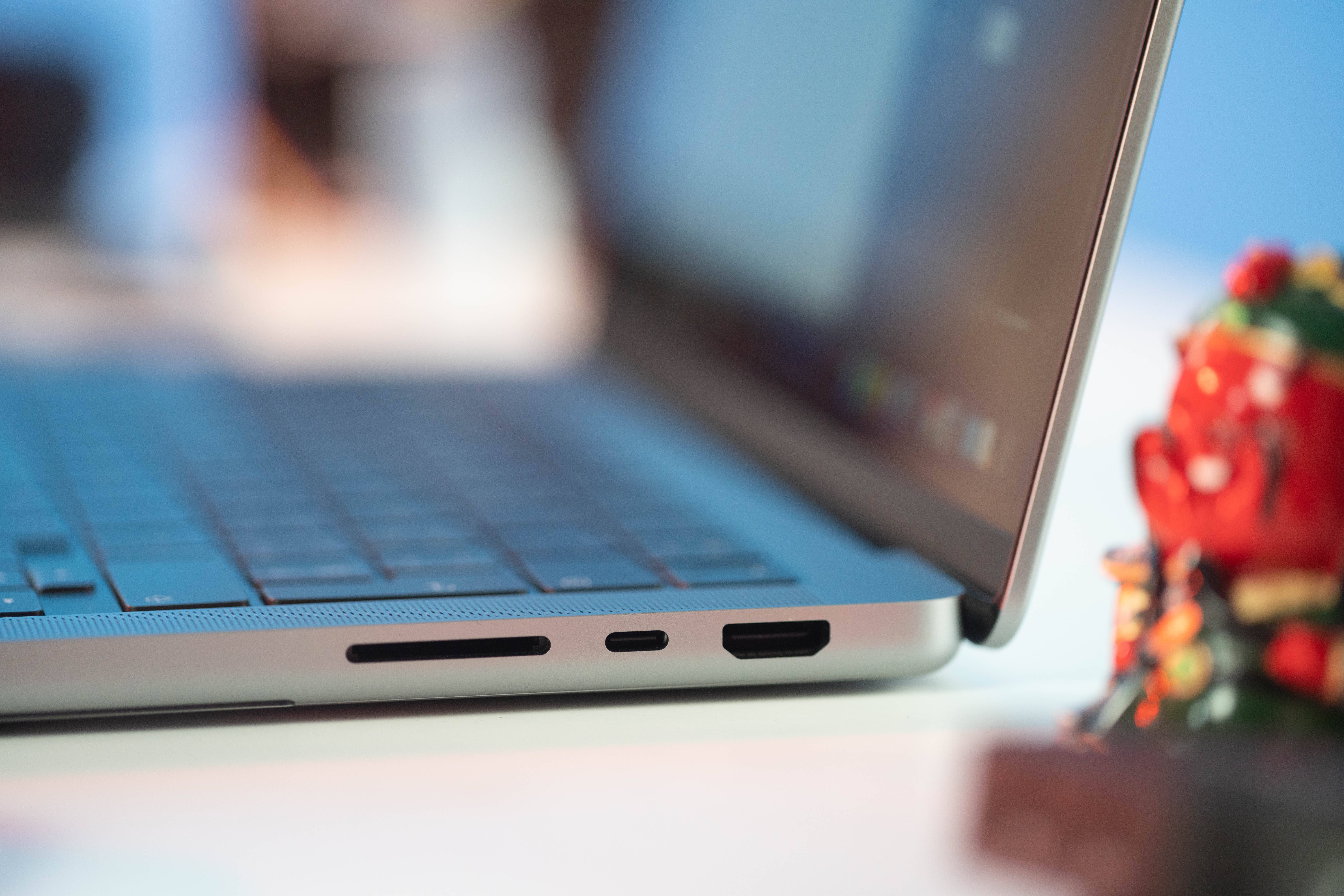 Surface 桌布 壁紙 — 銀色筆記型電腦側面連接埠的特寫，背景中有一個色彩繽紛的公仔模糊可見。