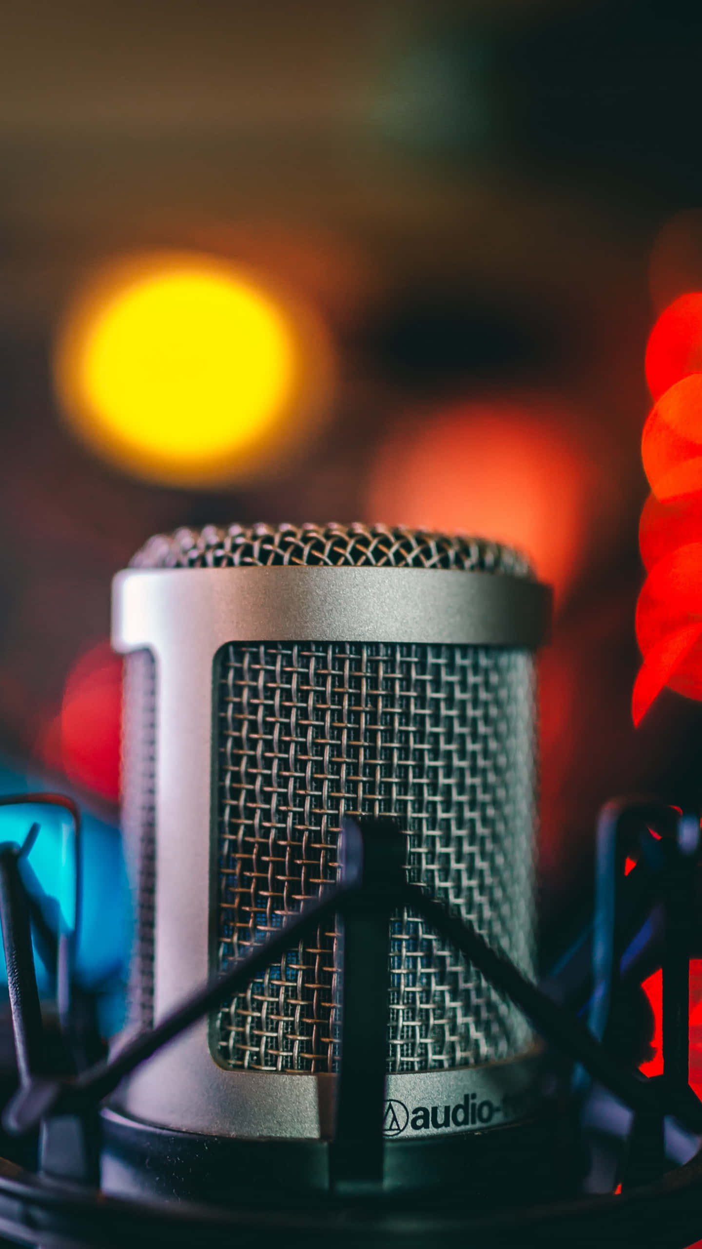 Sound 桌布 壁紙 — 銀色電容麥克風特寫，置於支架上，背景有彩色散景燈光。