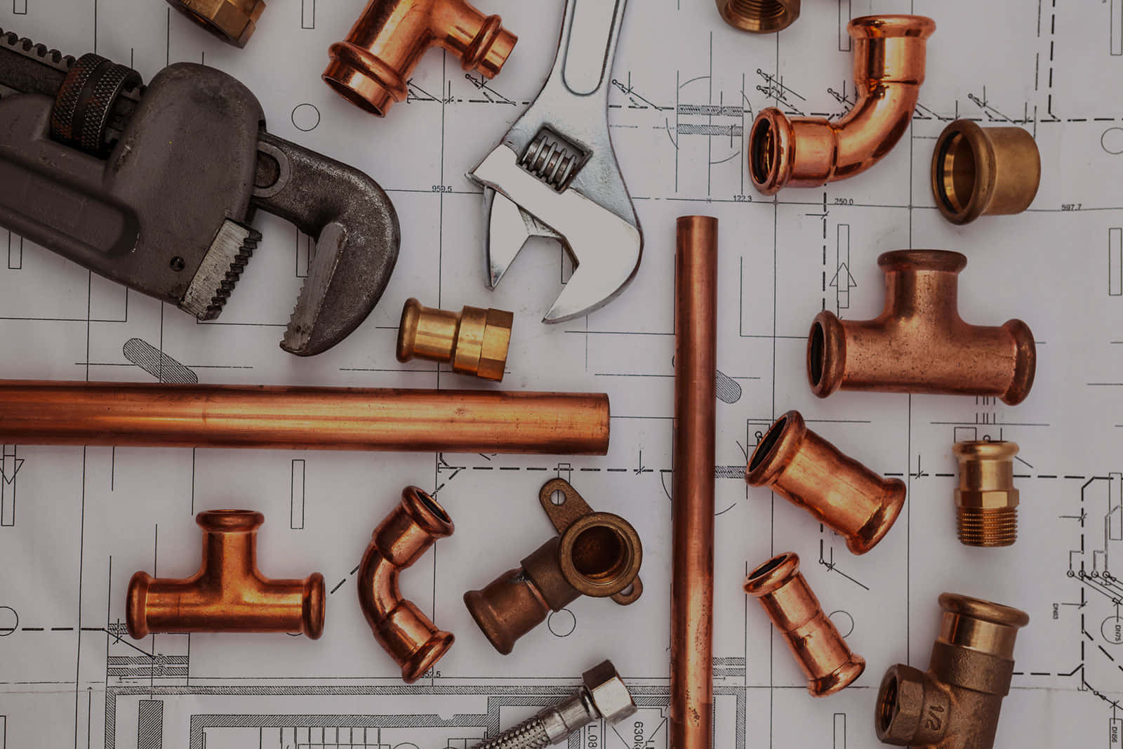 Plumbing 桌布 壁紙 — 銅管配件和扳手排列在藍圖上，顯示水管安裝細節。