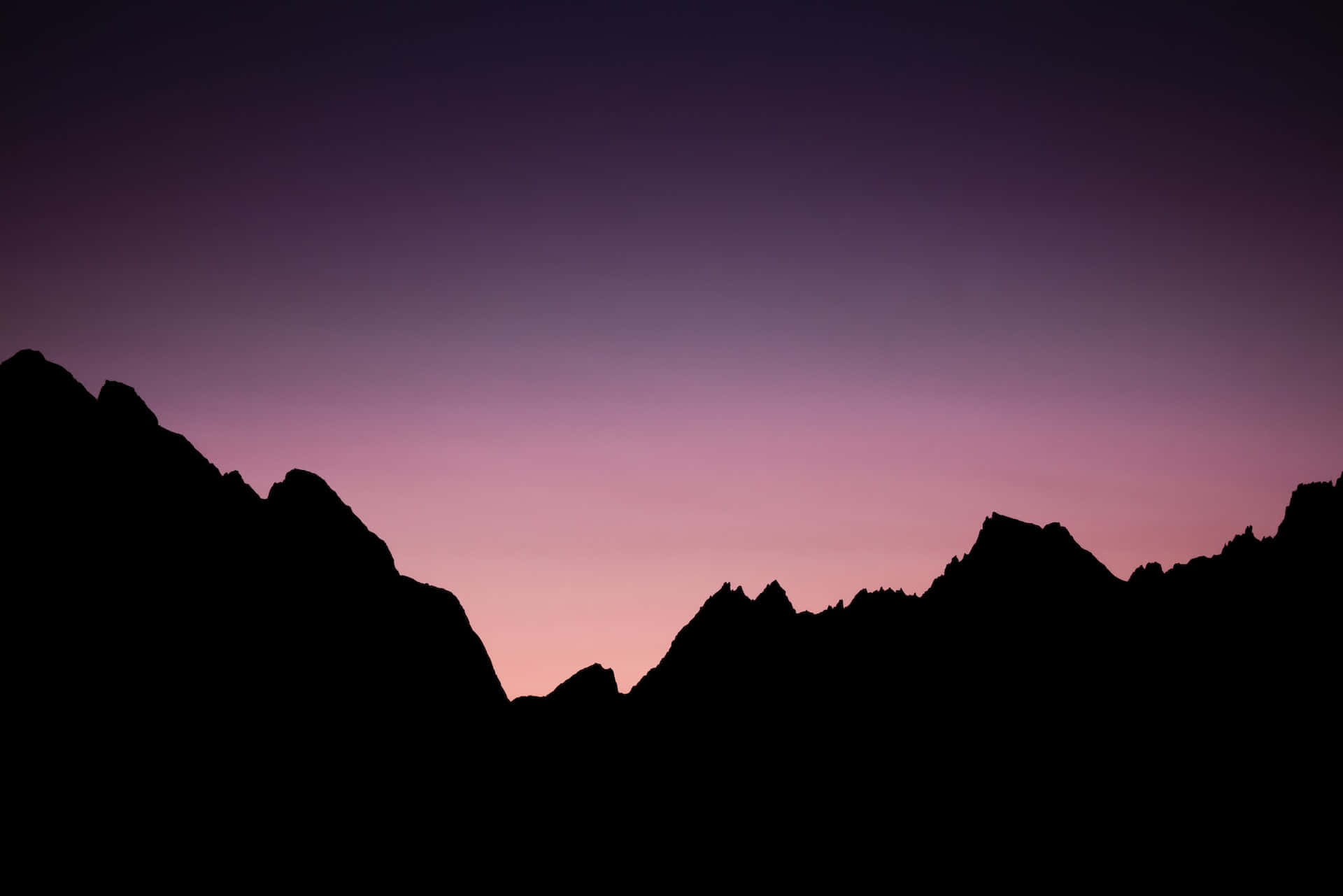 Mountain Landscape 桌布 壁紙 — 鋸齒狀山峰的剪影，映襯著深紫色和柔和粉紅色的漸變暮色天空。