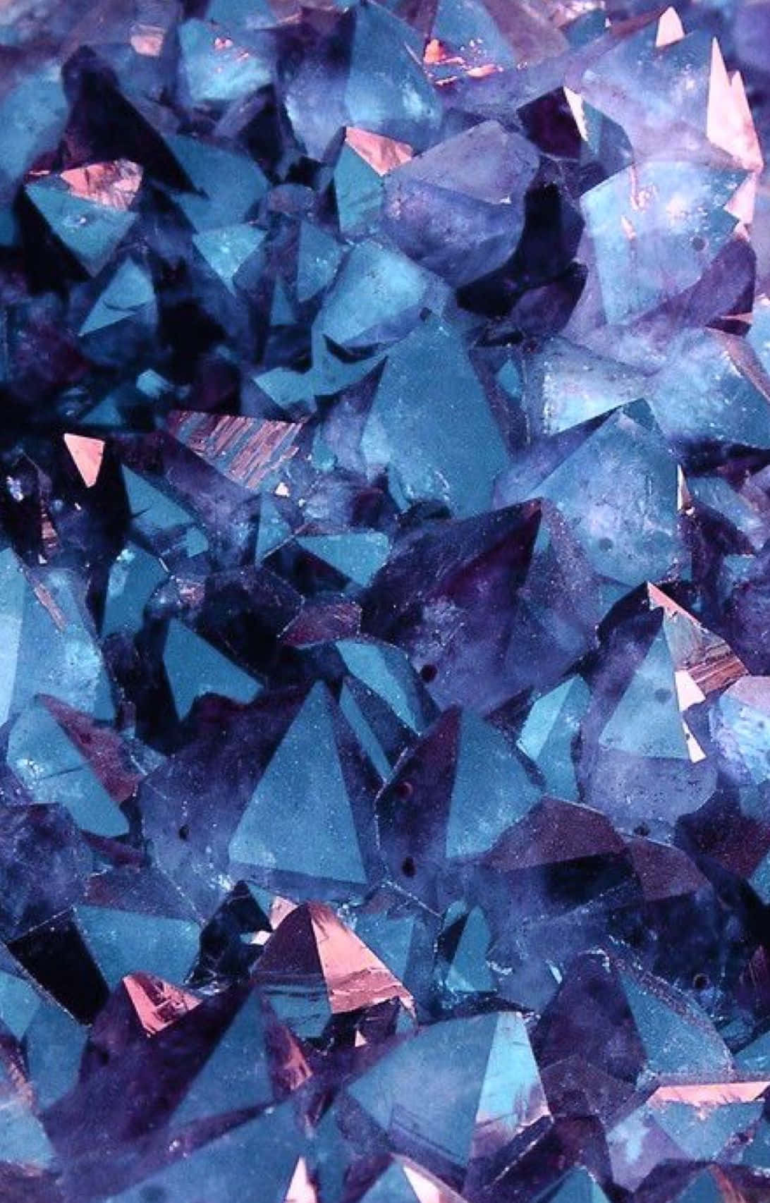 Diamond Aesthetic 桌布 壁紙 — 鋸齒狀藍色和紫色水晶結構的特寫，帶有金屬粉紅色亮點反射光線。