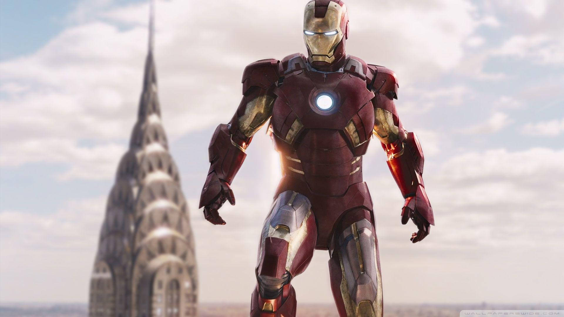 Iron Man Mark 3 桌布 壁紙 — 鋼鐵人在明亮的陰天下英雄地站在克萊斯勒大廈前。