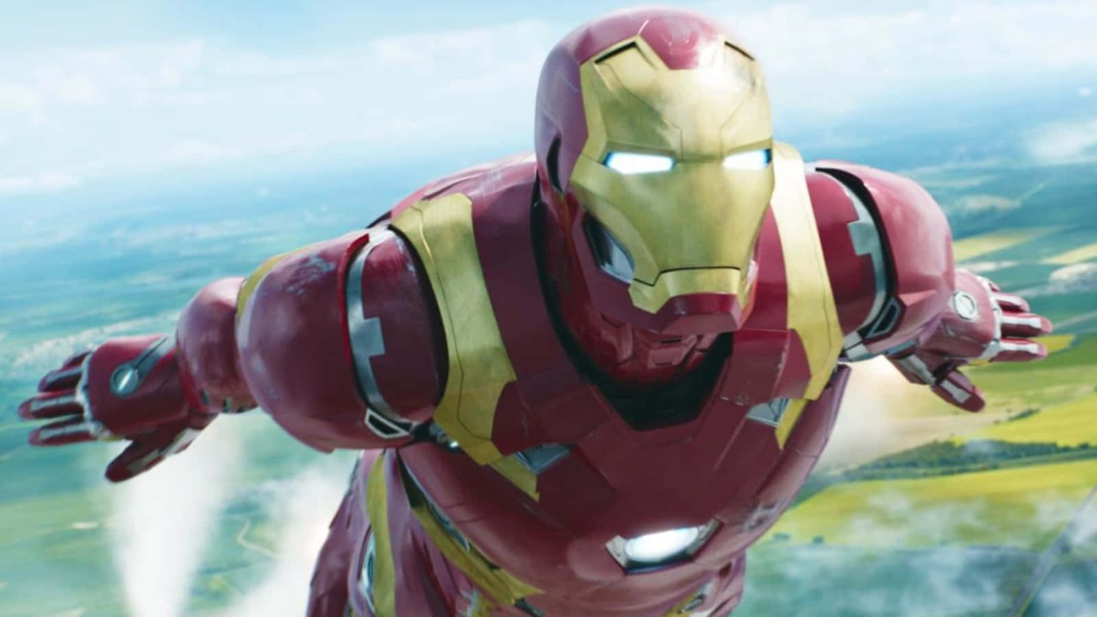 Vibranium Suit 桌布 壁紙 — 鋼鐵人在綠色景觀上空翱翔，身穿標誌性的紅金色戰衣，眼睛發光，並有斥力推進器。
