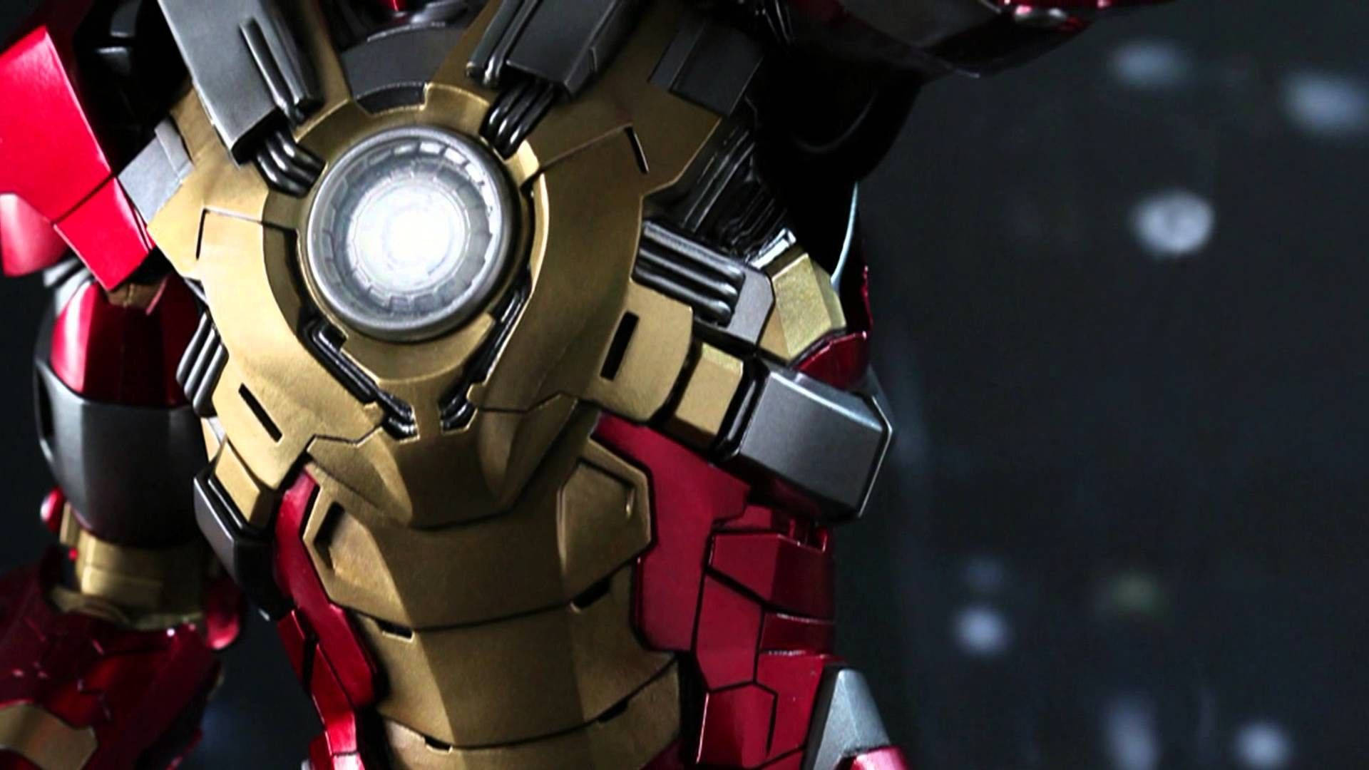 Iron Man Mark 3 桌布 壁紙 — 鋼鐵人發光弧形反應器的特寫，金色、紅色和黑色裝甲，背景為黑暗模糊。