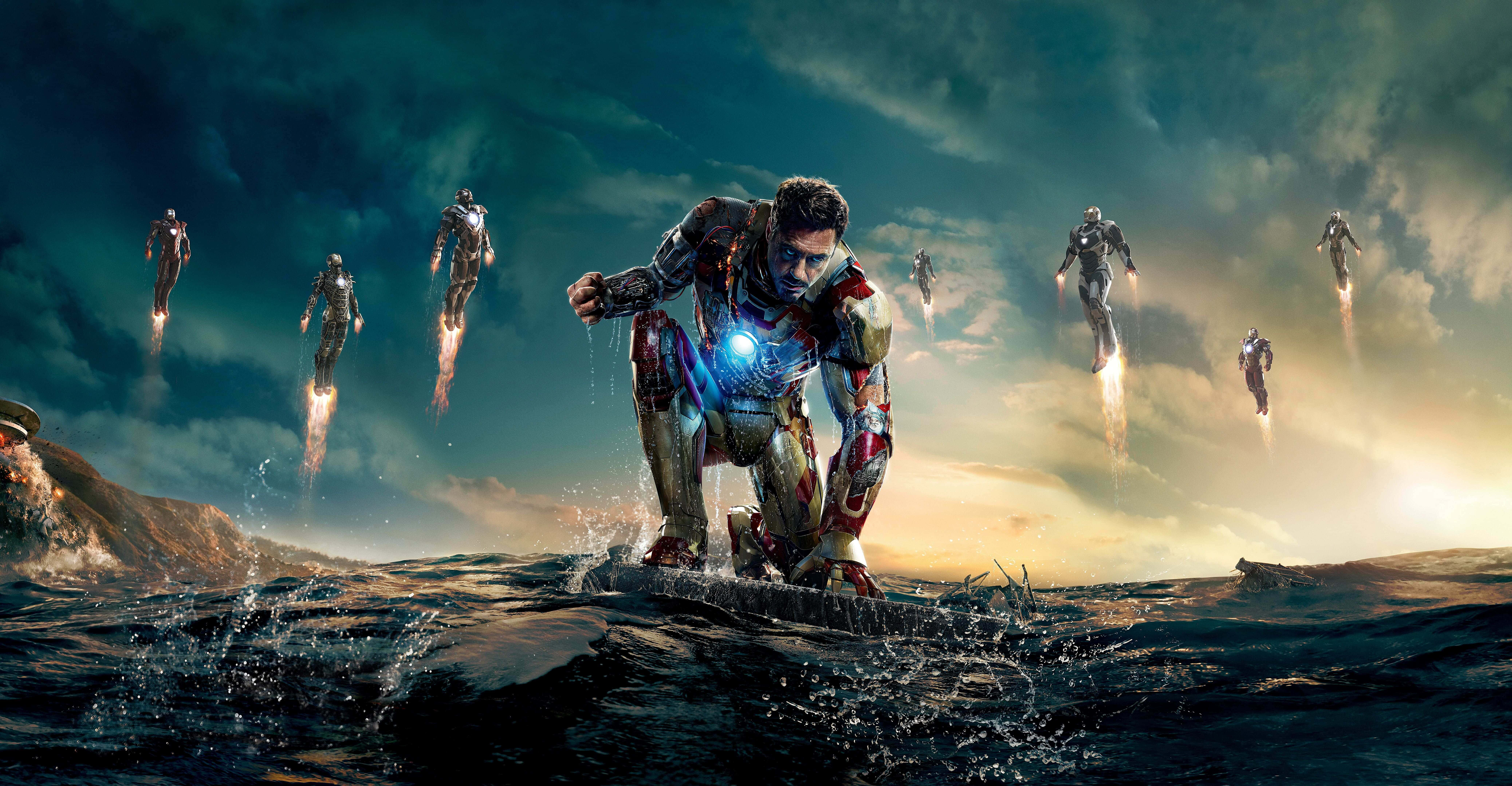 Iron Man Movies 桌布 壁紙 — 鋼鐵人跪在海浪中，多個鋼鐵人裝甲在戲劇性的日落天空背景下飛過頭頂。