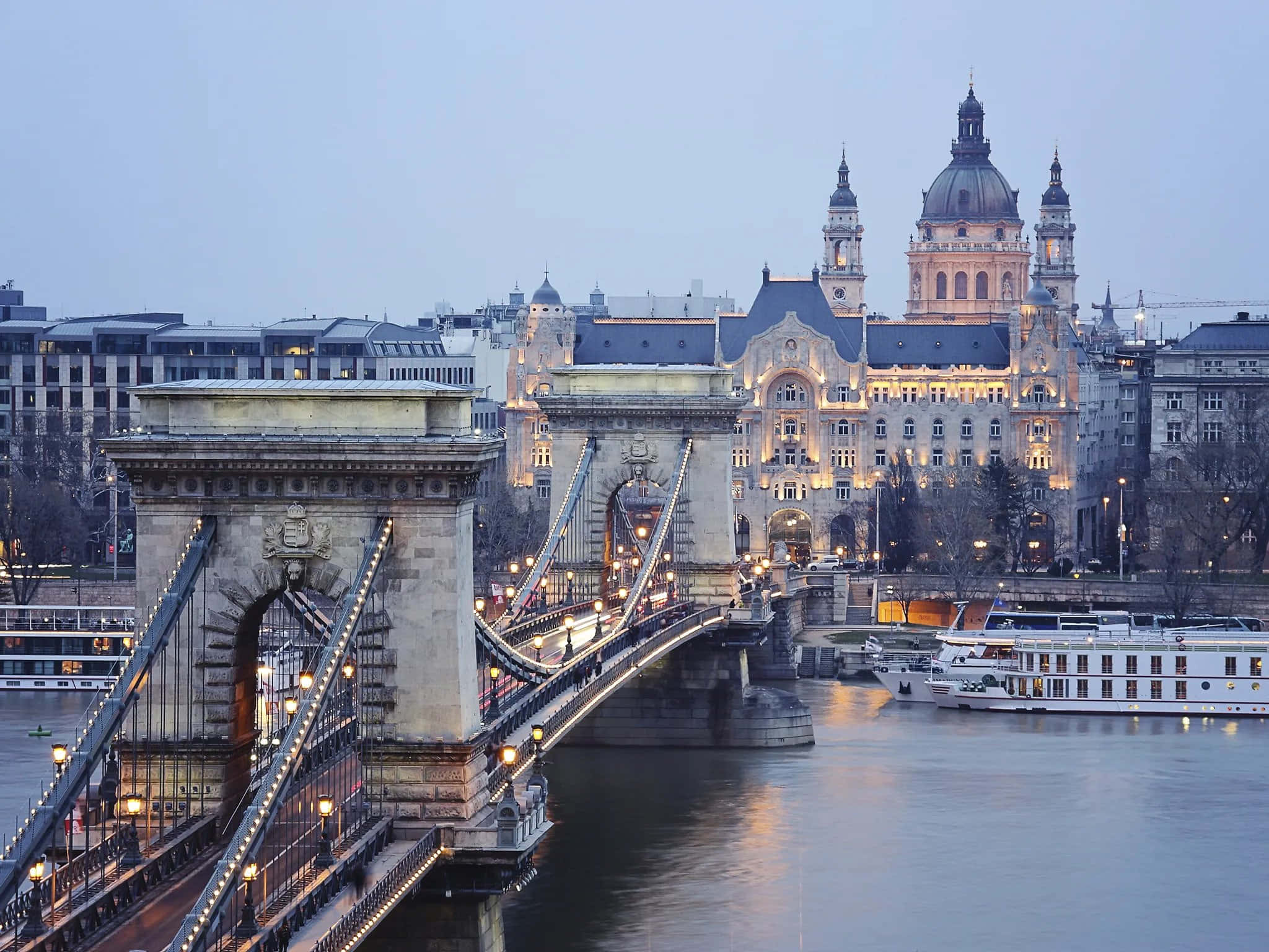 Europe 桌布 壁紙 — 鏈橋在多瑙河上閃爍著溫暖的燈光，暮色降臨在布達佩斯的歷史建築上。