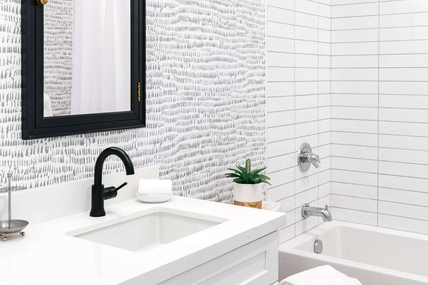 bathroom 桌布 壁紙 — 鏡後帶有白色梳妝台、黑色水龍頭和紋理灰色壁紙的現代浴室。