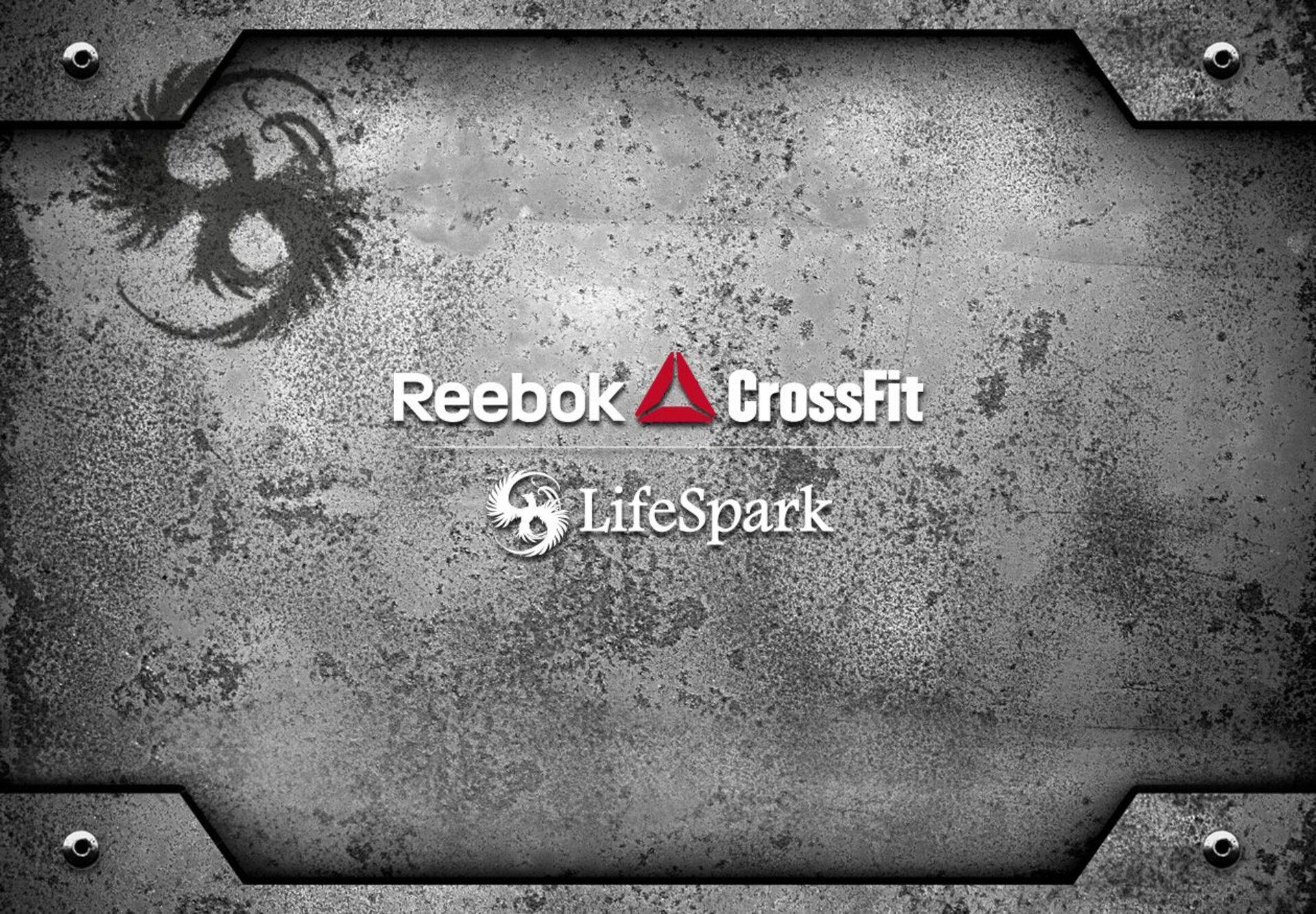 銳步 桌布 壁紙 — 鏽蝕金屬板，中央放置 Reebok CrossFit 和 LifeSpark 標誌，背景為粗糙工業質感。