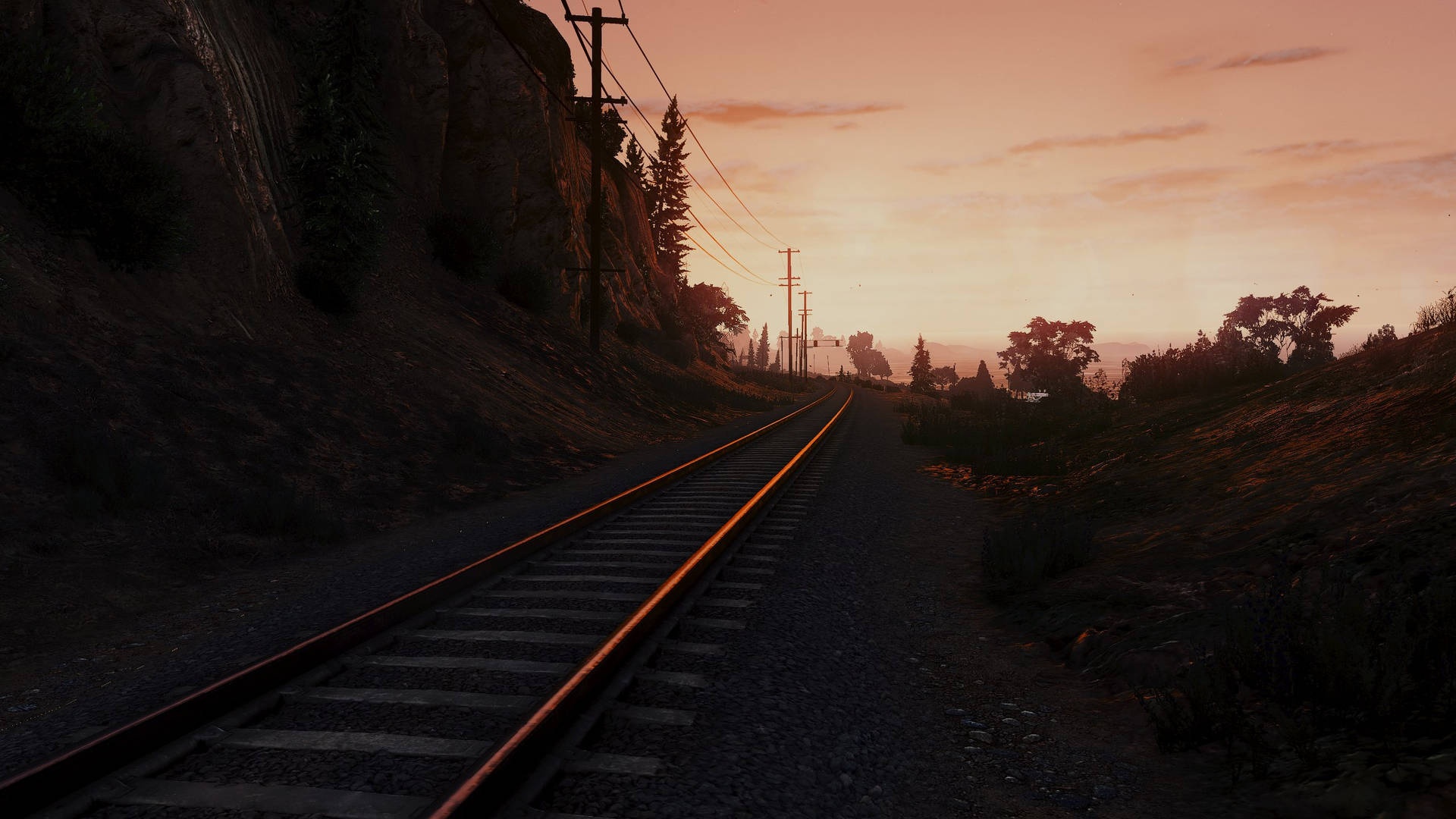 日落時分，鐵路軌道蜿蜒穿過丘陵，伴隨著橙色天空和樹木剪影。 — GTA 5 動圖 壁紙