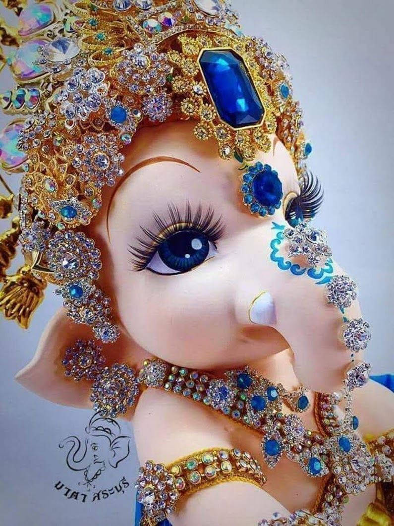cute ganesha 桌布 壁紙 — 鑲有寶石的小象神祇近距離特寫，飾有金色和藍色寶石以及長長的睫毛。