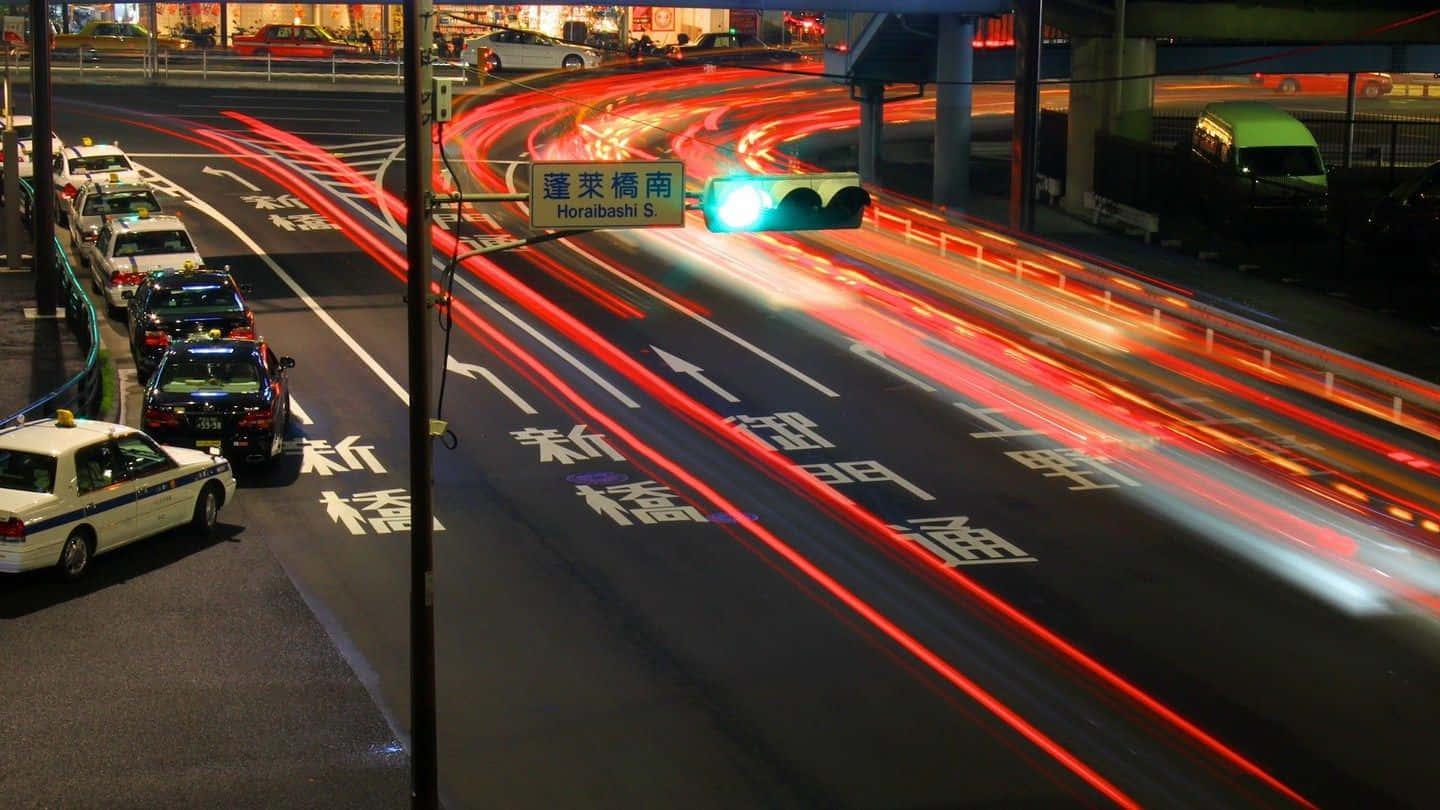 Road 桌布 壁紙 — 長時間曝光捕捉到夜間繁忙東京高速公路上紅色尾燈和白色頭燈的流動痕跡。