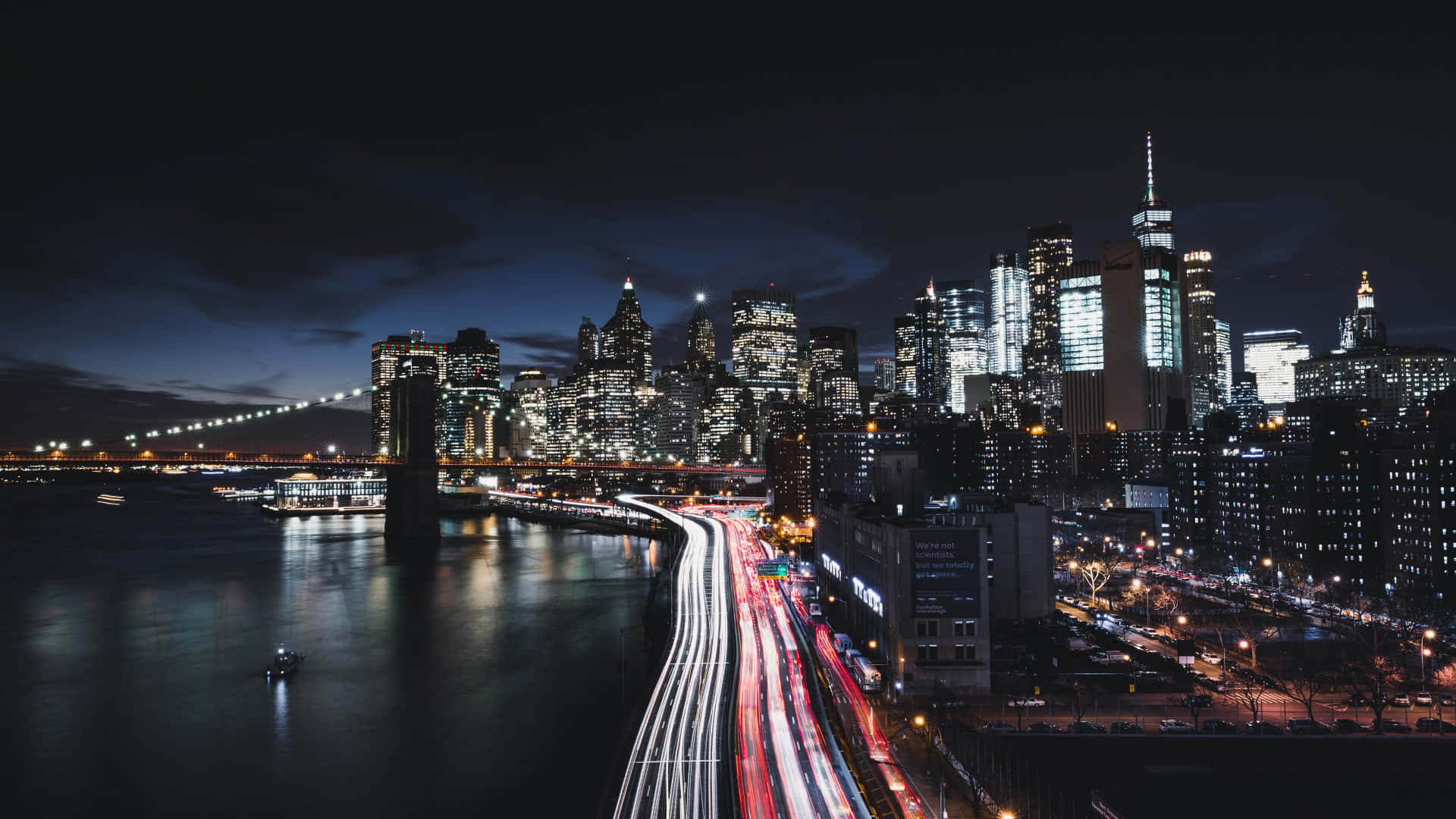 City Night 桌布 壁紙 — 長時間曝光捕捉到流動的交通燈光和發光的摩天大樓照亮布魯克林大橋的夜景。
