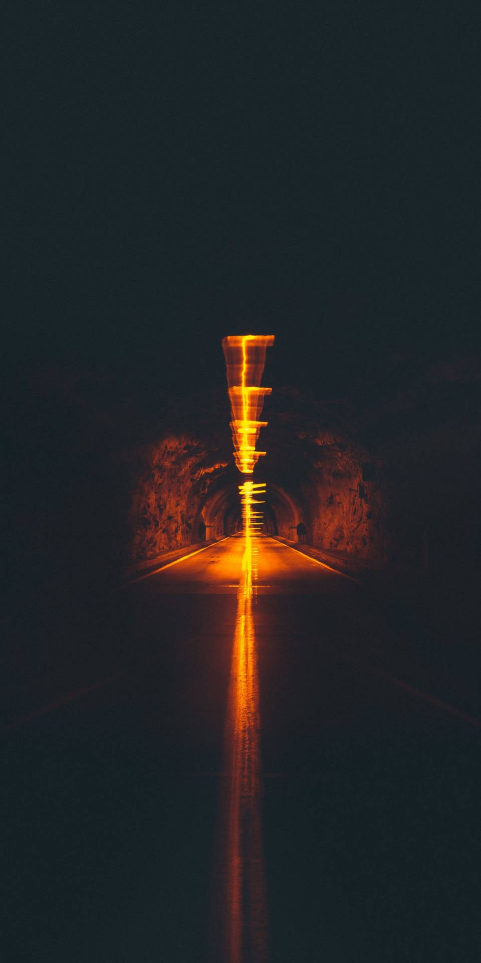 tunnel 桌布 壁紙 — 長時間曝光捕捉到黑暗隧道內行駛車輛發出的橙色光軌。