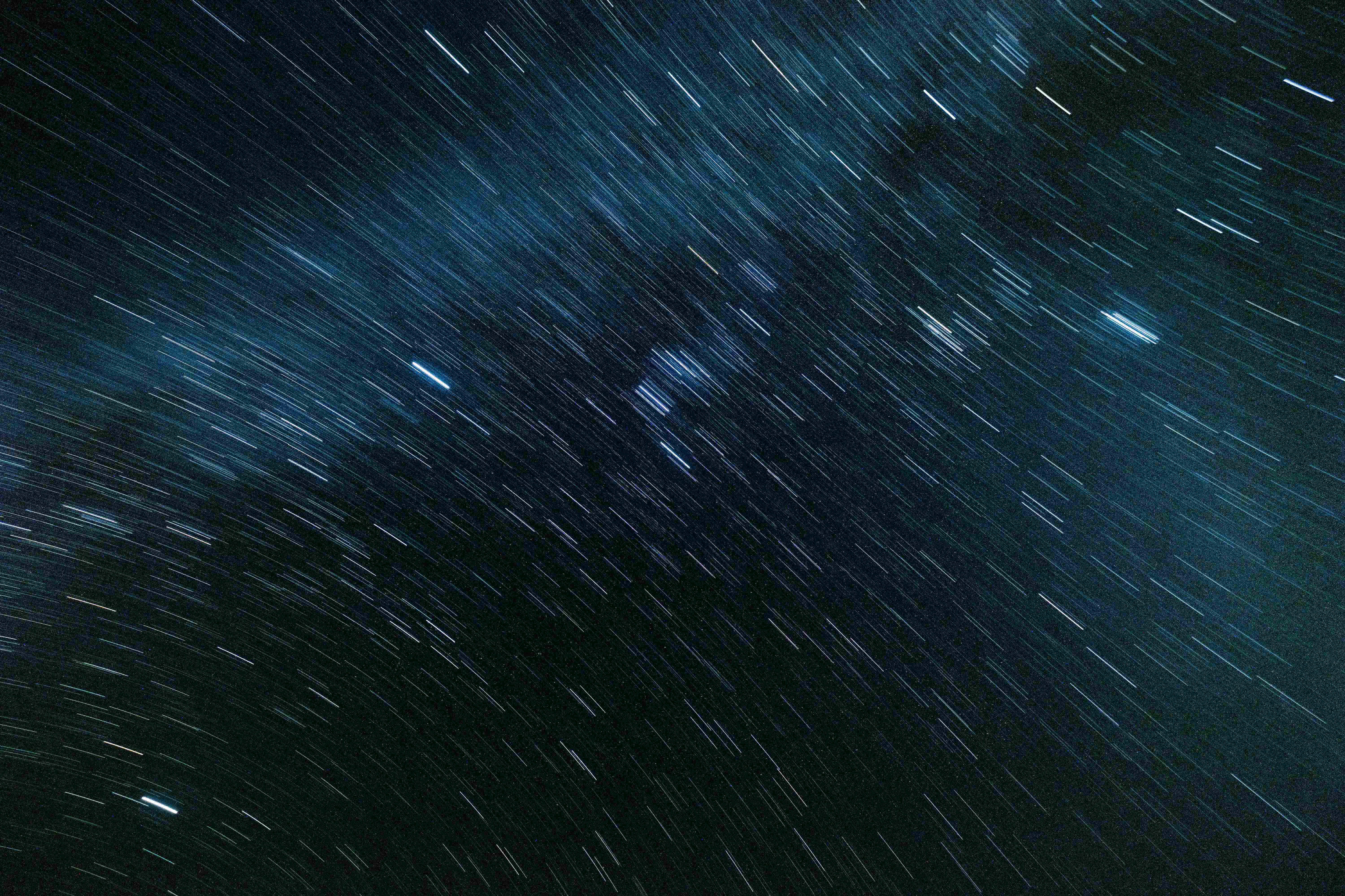 Black Space 桌布 壁紙 — 長時間曝光攝影捕捉到的星空，帶有移動星星產生的長藍白色光跡。