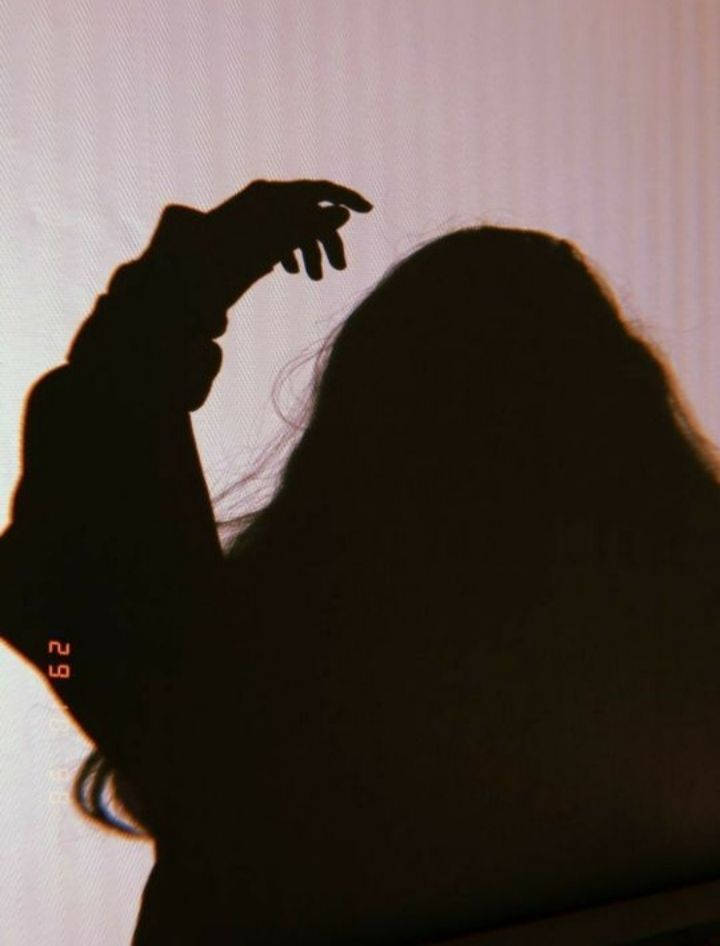 Woman Silhouette 桌布 壁紙 — 長髮人物的剪影，伸手觸碰頭部，背景為柔和粉紅色。