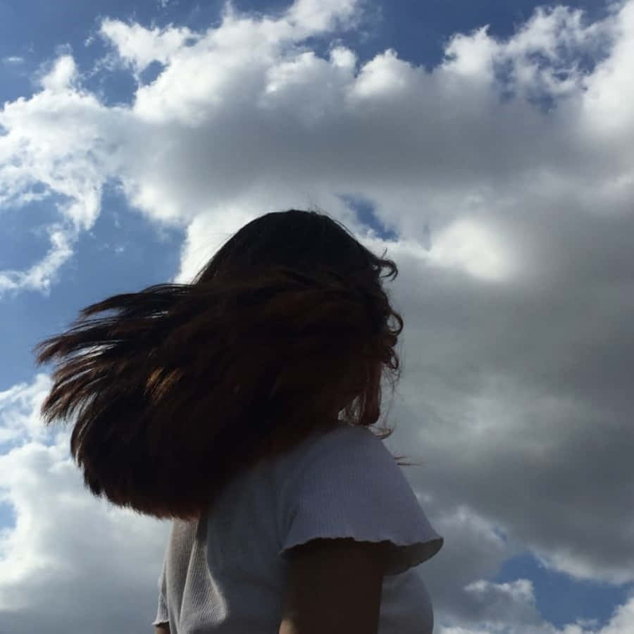 長髮女子站在藍天前的照片 壁紙