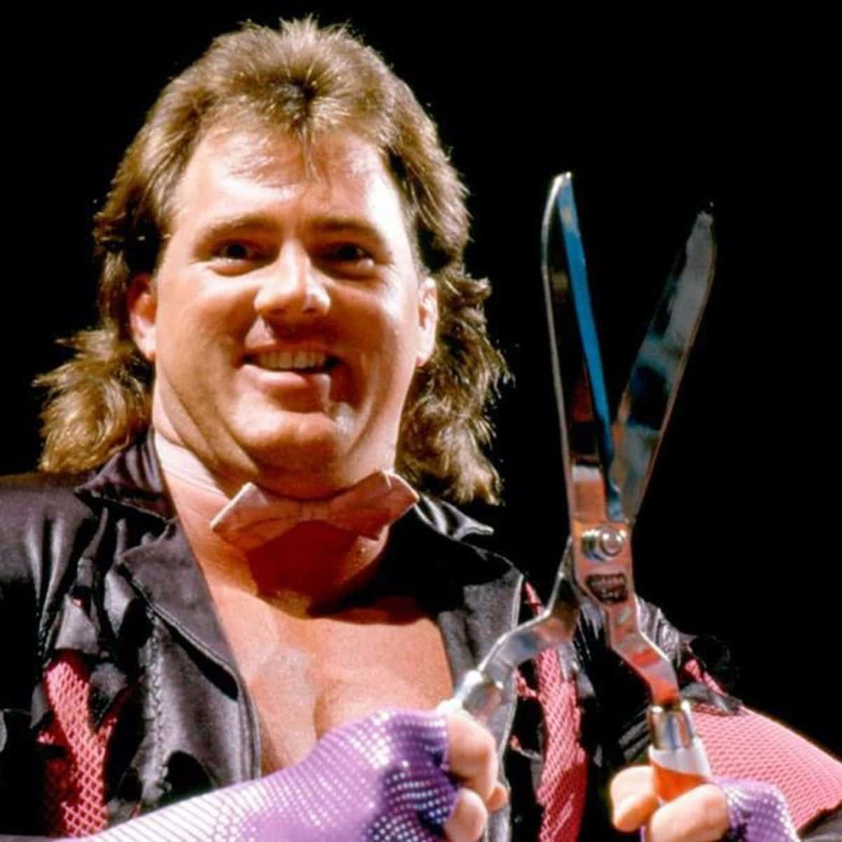 WWE 桌布 壁紙 — 長髮摔角手戴著紫色手套，在黑色背景前拿著一把巨大的剪刀。