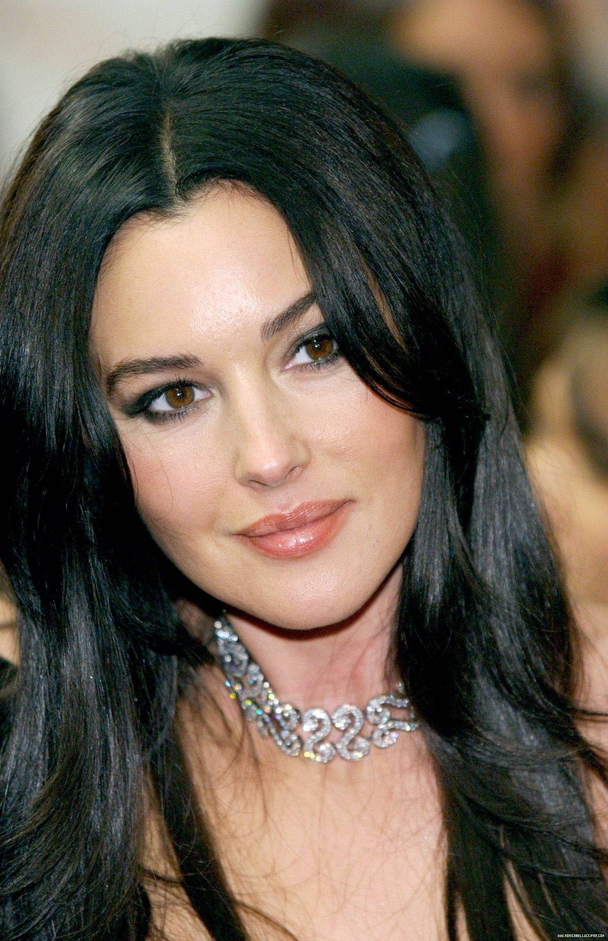 monica bellucci 桌布 壁紙 — 長黑髮女性佩戴閃爍鑽石頸鏈的特寫肖像。