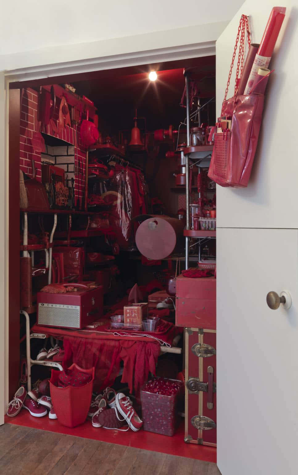 Red Room 桌布 壁紙 — 門口揭示一個雜亂的衣櫃，在溫暖燈光下堆滿了紅色鞋子、手提袋和復古物品。