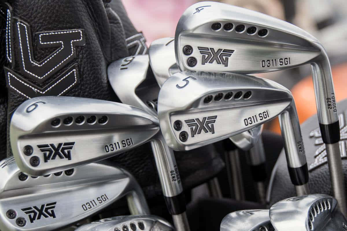 Golf Club 桌布 壁紙 — 閃亮 PXG 高爾夫鐵桿的特寫，黑色握把，放置在帶有白色縫線的黑色高爾夫球袋中。