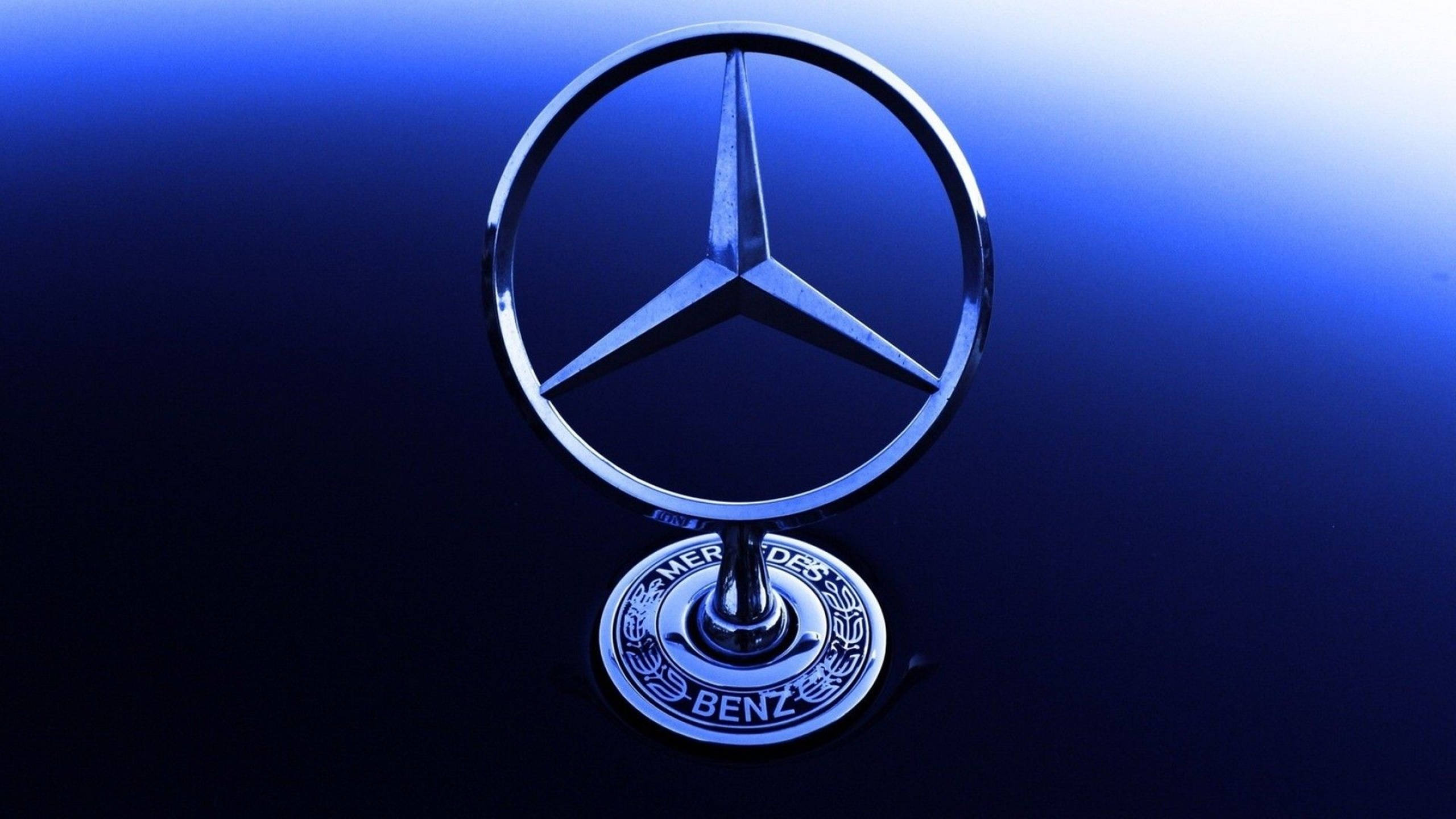 藍色 桌布 壁紙 — 閃亮的 Mercedes-Benz 標誌在冷藍光下，在漸層深藍色背景上閃耀。