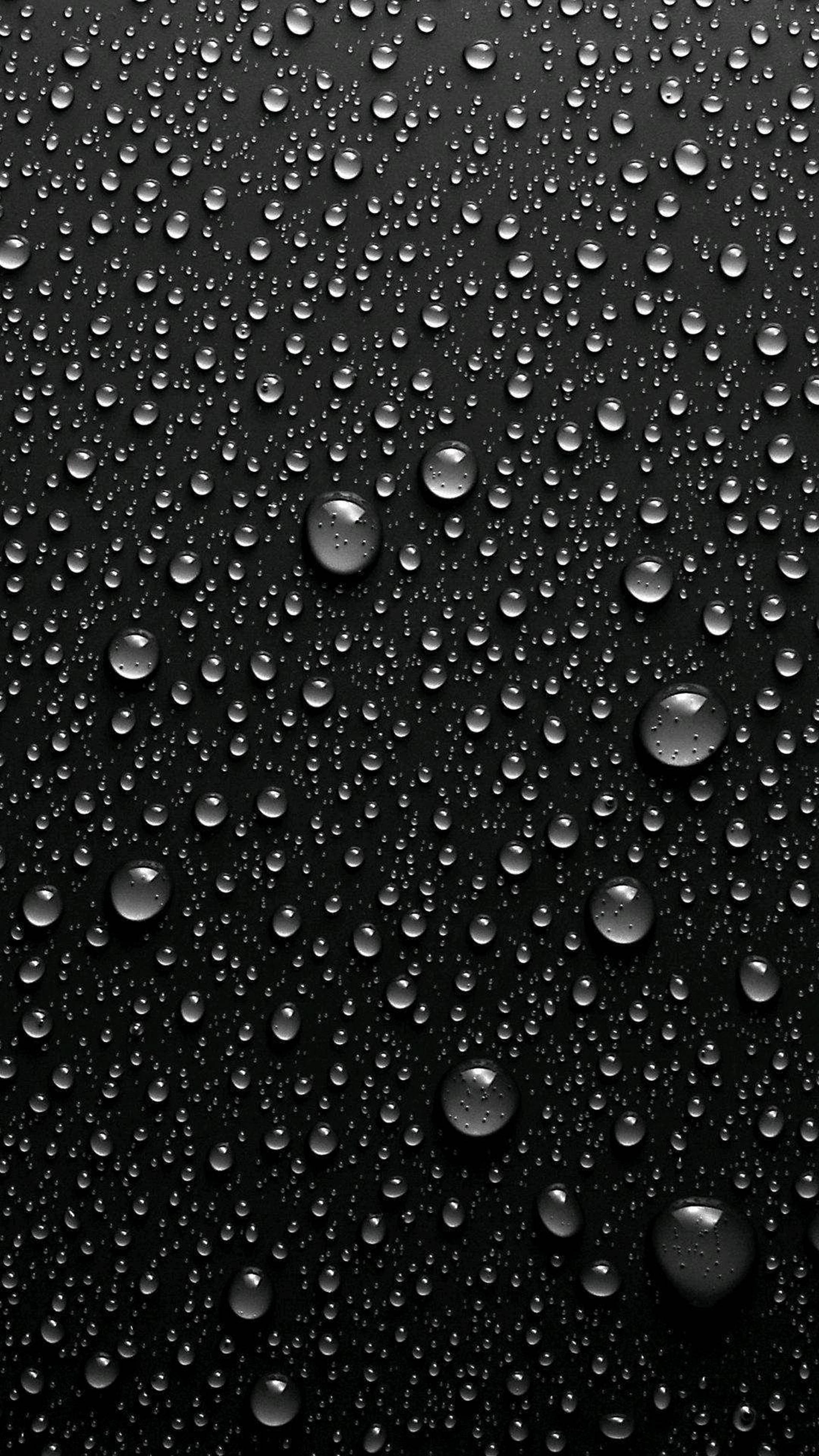 黑色 iPhone 桌布 桌布 壁紙 — 閃亮的水滴依附在光滑的黑色表面上，營造出極簡的單色紋理。