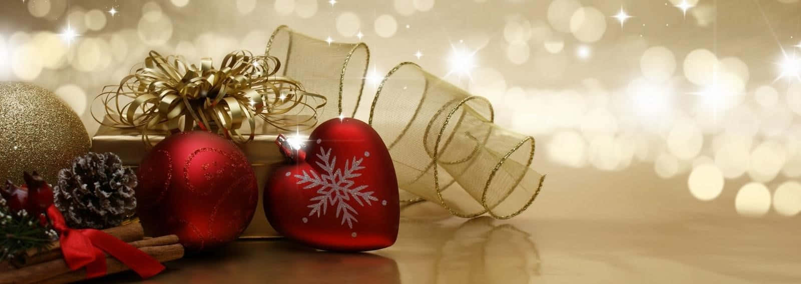 Gold Christmas 桌布 壁紙 — 閃亮的紅色心形裝飾品帶有雪花設計，旁邊放著金色蝴蝶結、松果和肉桂棒，在木質表面上，背景有散景燈光。