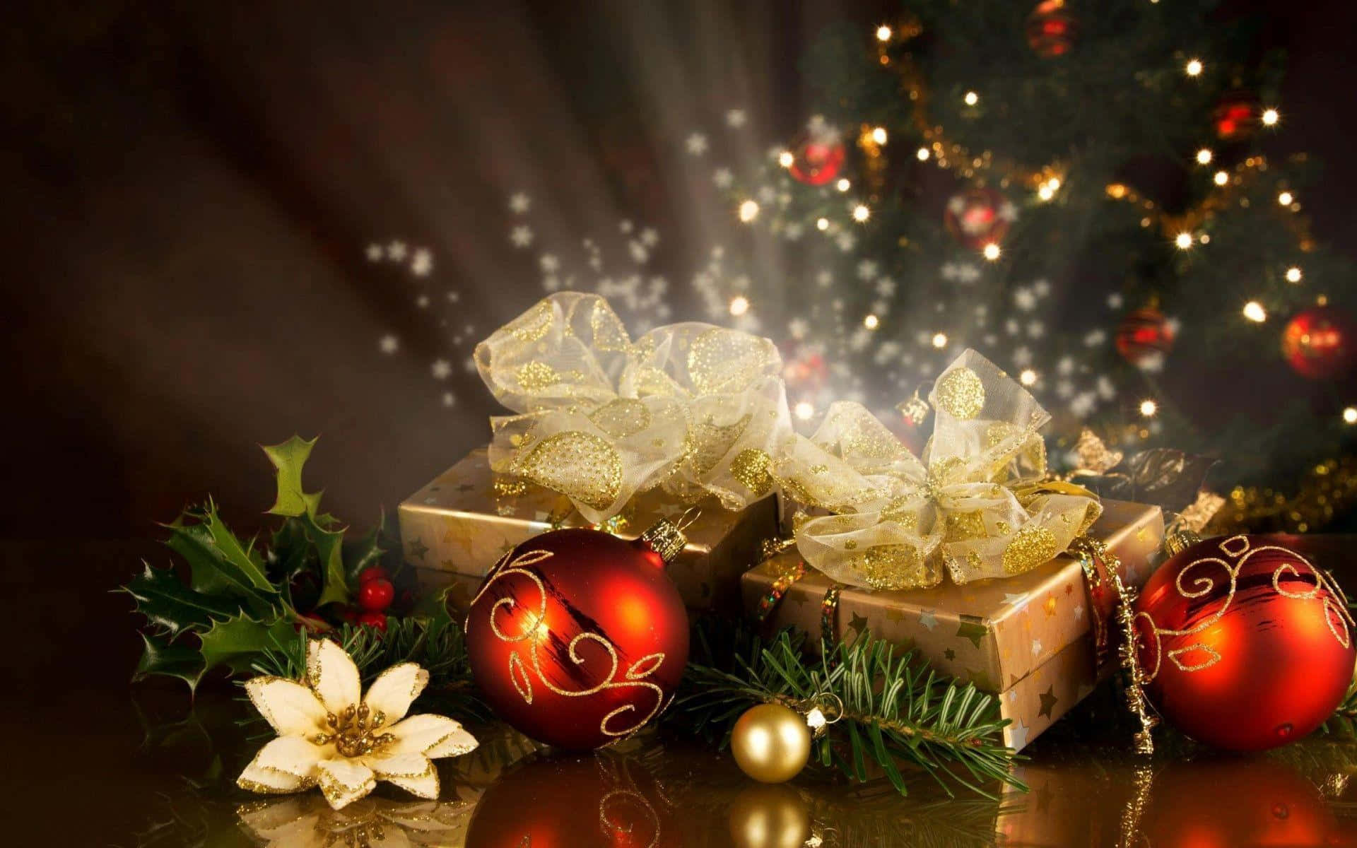 gifts 桌布 壁紙 — 閃亮的紅色裝飾品和金色包裝的禮物放在冬青和松樹旁，在溫暖的節日燈光下。