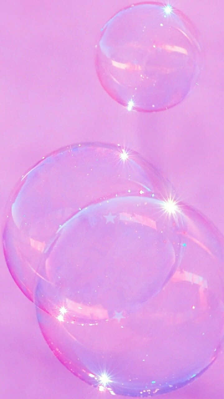 Sparkle Aesthetic 桌布 壁紙 — 閃亮的肥皂泡在柔和的粉紅色背景上漂浮，帶有星光閃爍和鏡頭光暈。