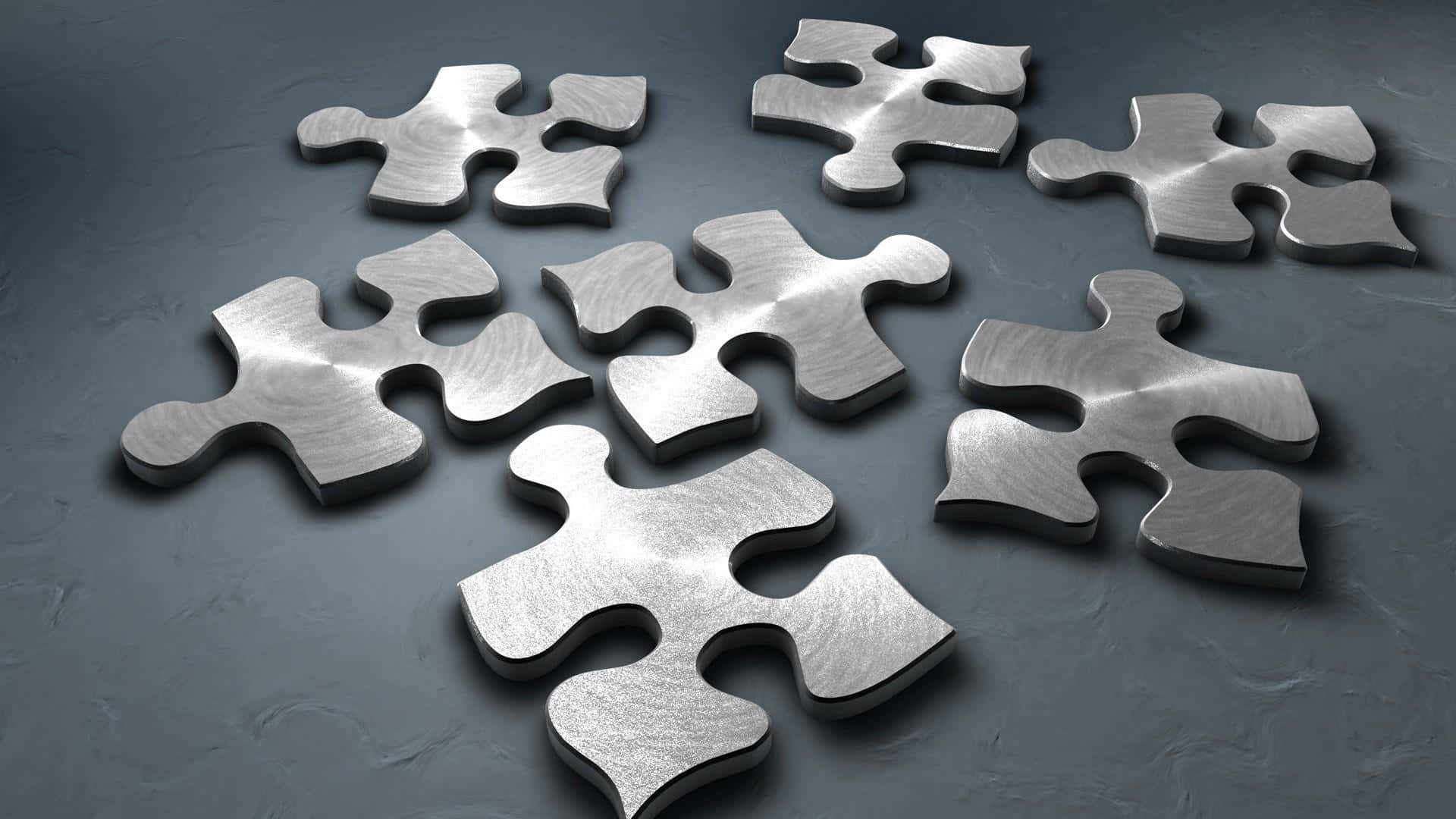 Puzzle 桌布 壁紙 — 閃亮的金屬拼圖碎片散落在帶有柔和光線的深色紋理表面上。