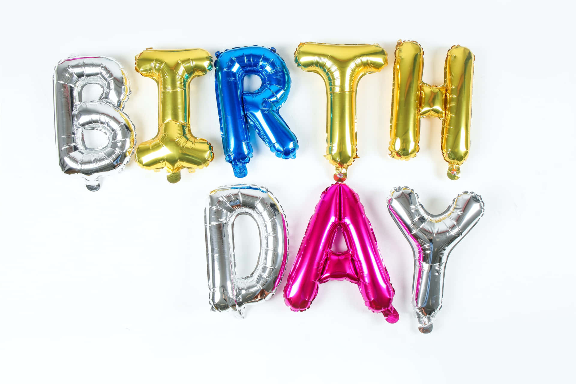 生日快樂 桌布 壁紙 — 閃亮的金屬氣球在潔白背景上拼出 'BIRTHDAY'，色彩鮮豔。