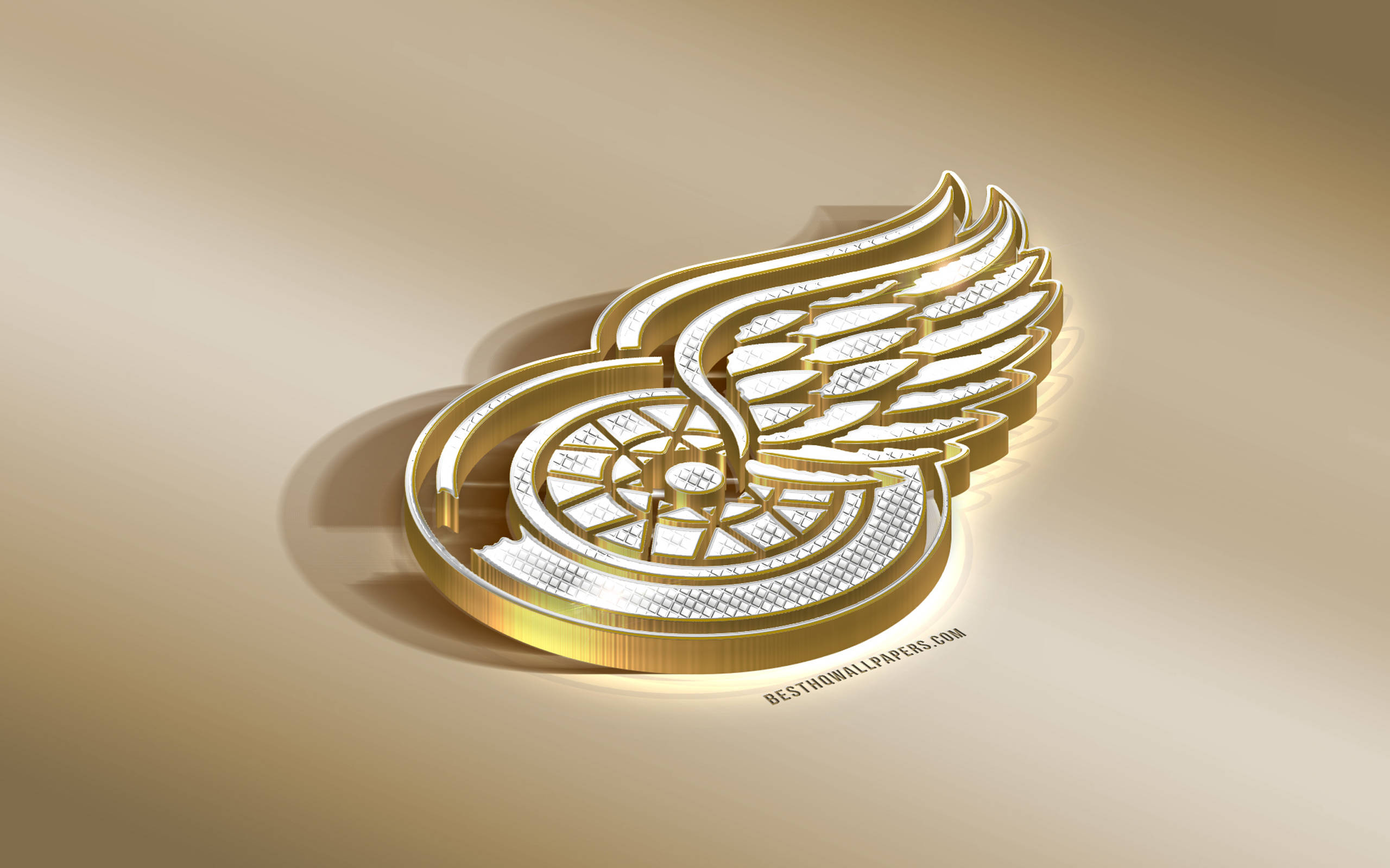 Detroit Red Wings 桌布 壁紙 — 閃亮的金色底特律紅翼標誌，帶有複雜的翅膀細節，在溫暖的米色表面上投下柔和的陰影。