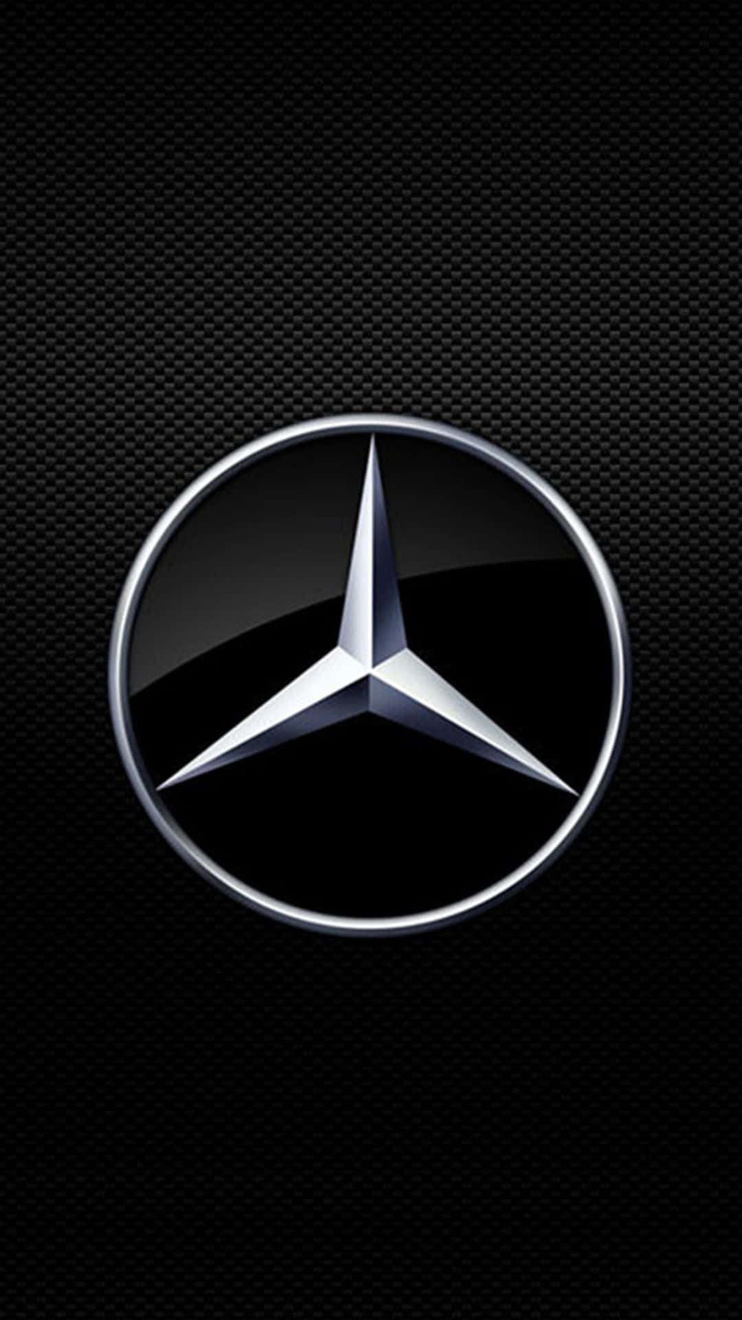桌布 壁紙 — 閃亮的銀色 Mercedes-Benz 標誌居中於有紋理的黑色碳纖維背景上。