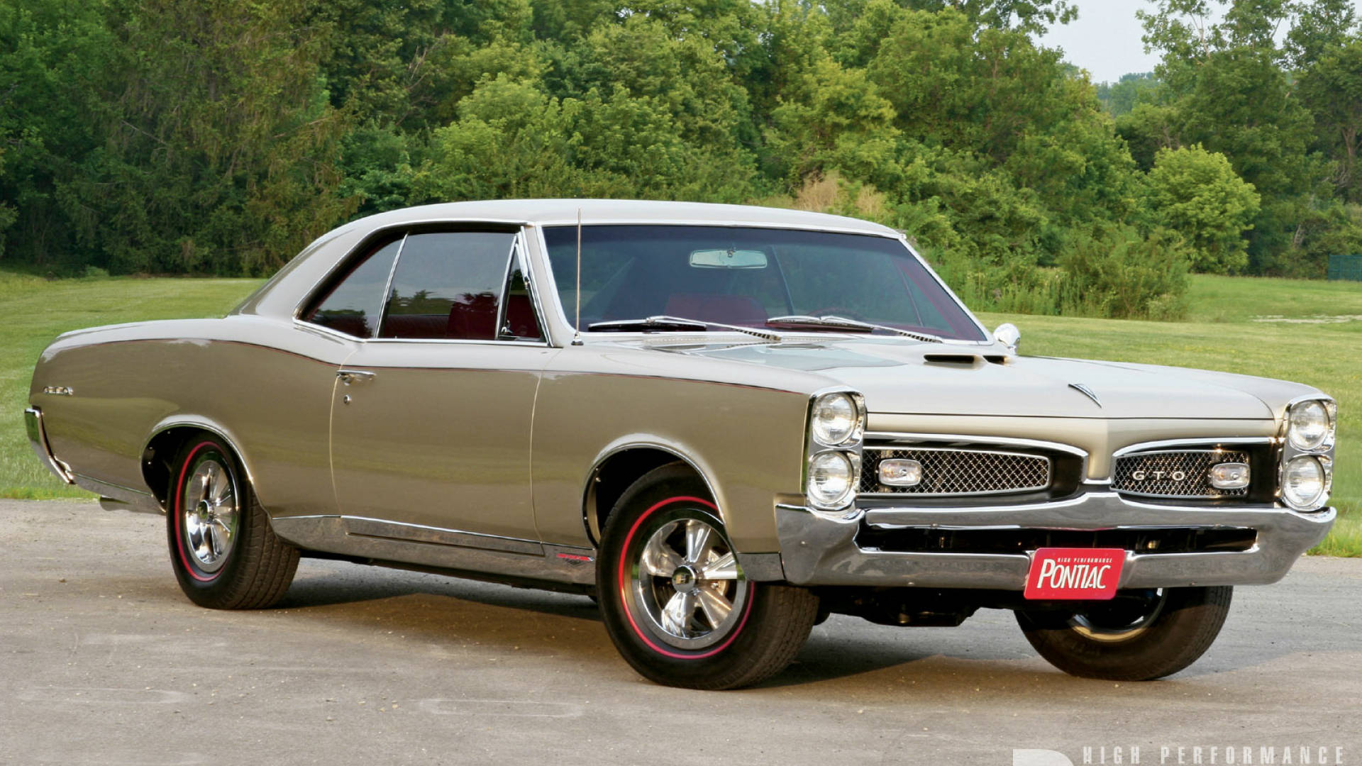 Pontiac 桌布 壁紙 — 閃亮的銀色1967年龐蒂克GTO肌肉車停在瀝青路面上，背景是茂密的綠樹。