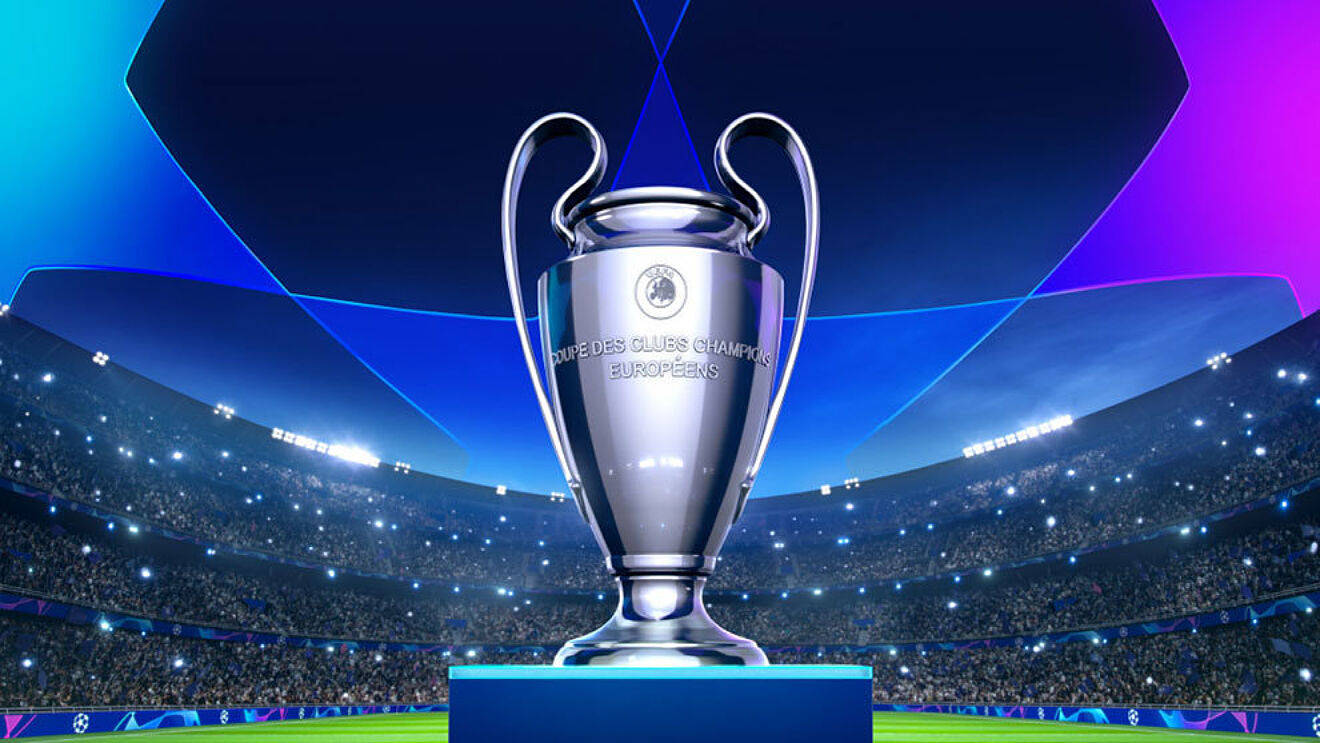Uefa 桌布 壁紙 — 閃亮的銀色歐冠獎盃在球場燈光下閃爍，背景有歡呼的球迷。